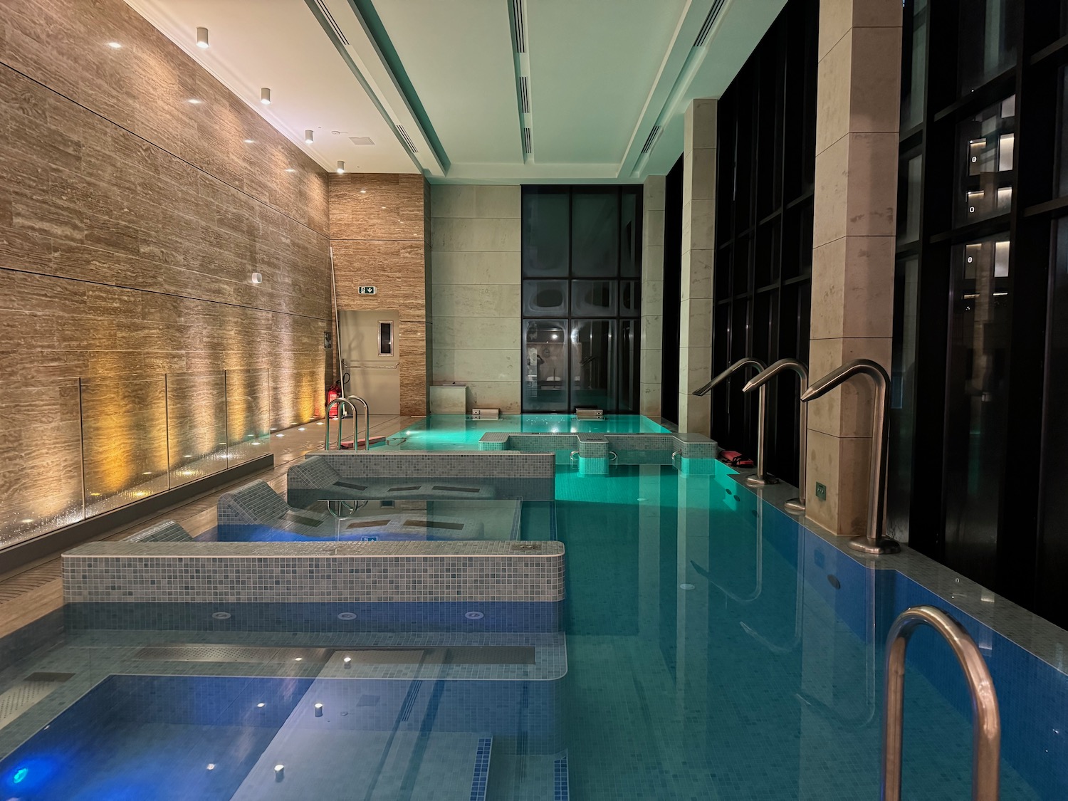 a indoor swimming pool with a large glass wall