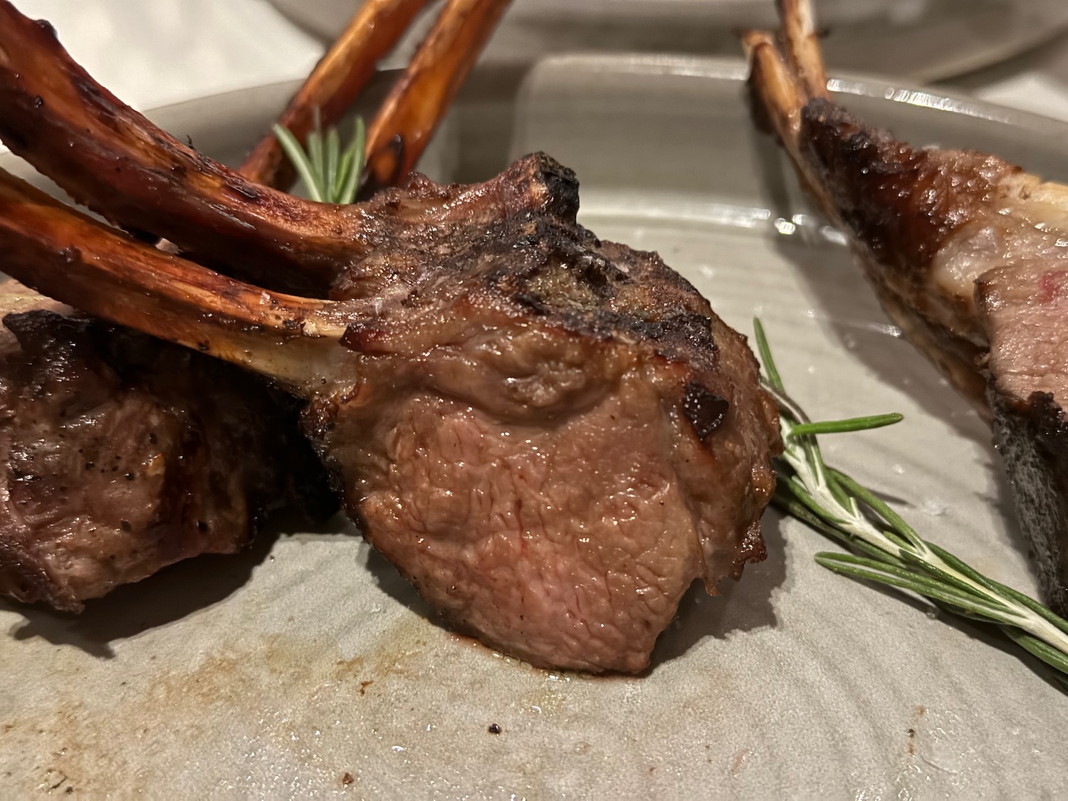 a plate of meat with rosemary on it