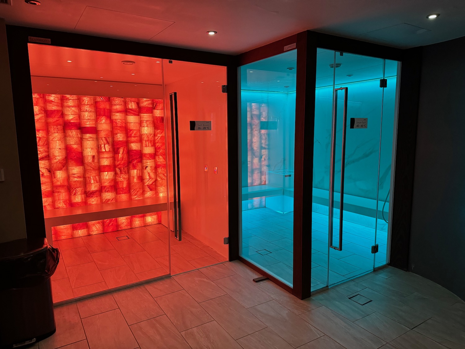 a sauna with glass doors and a red and blue curtain
