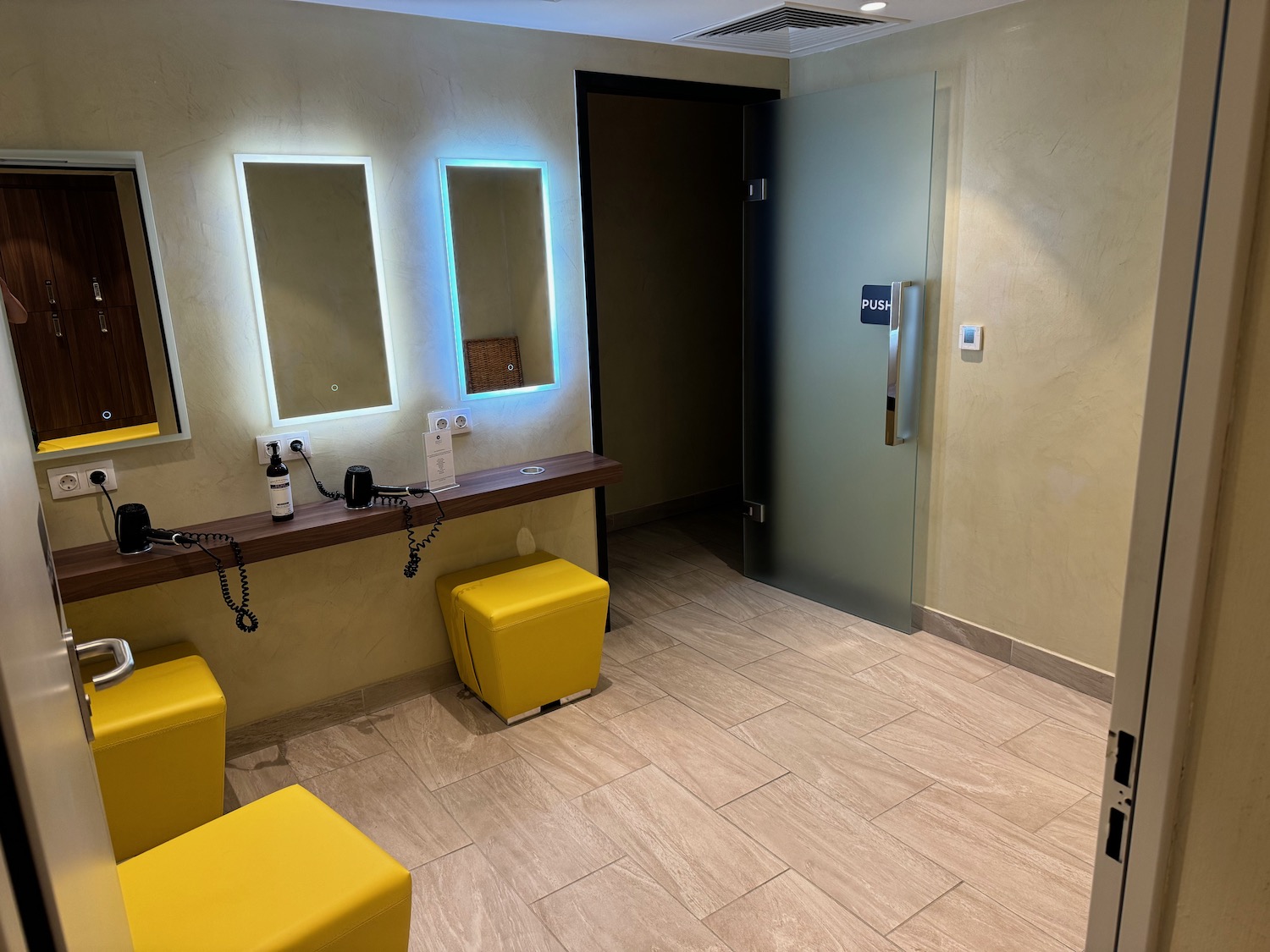 a room with yellow stools and mirrors