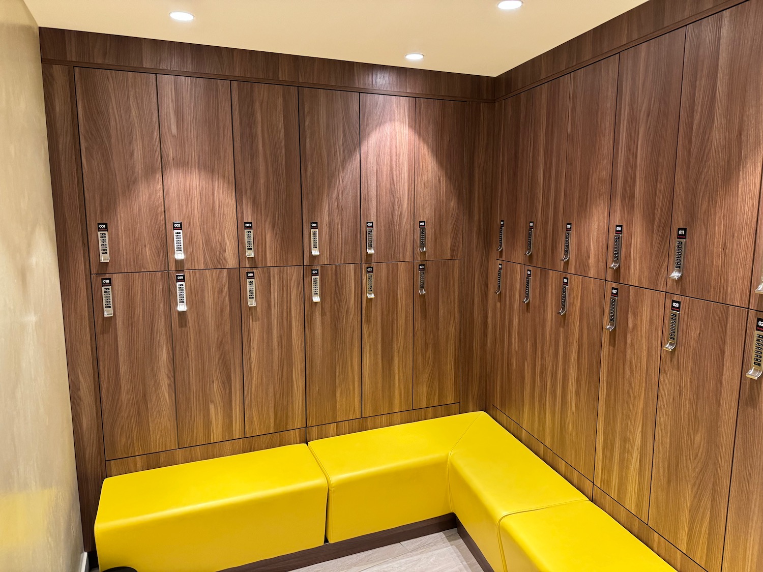 a locker room with yellow benches and wooden cabinets