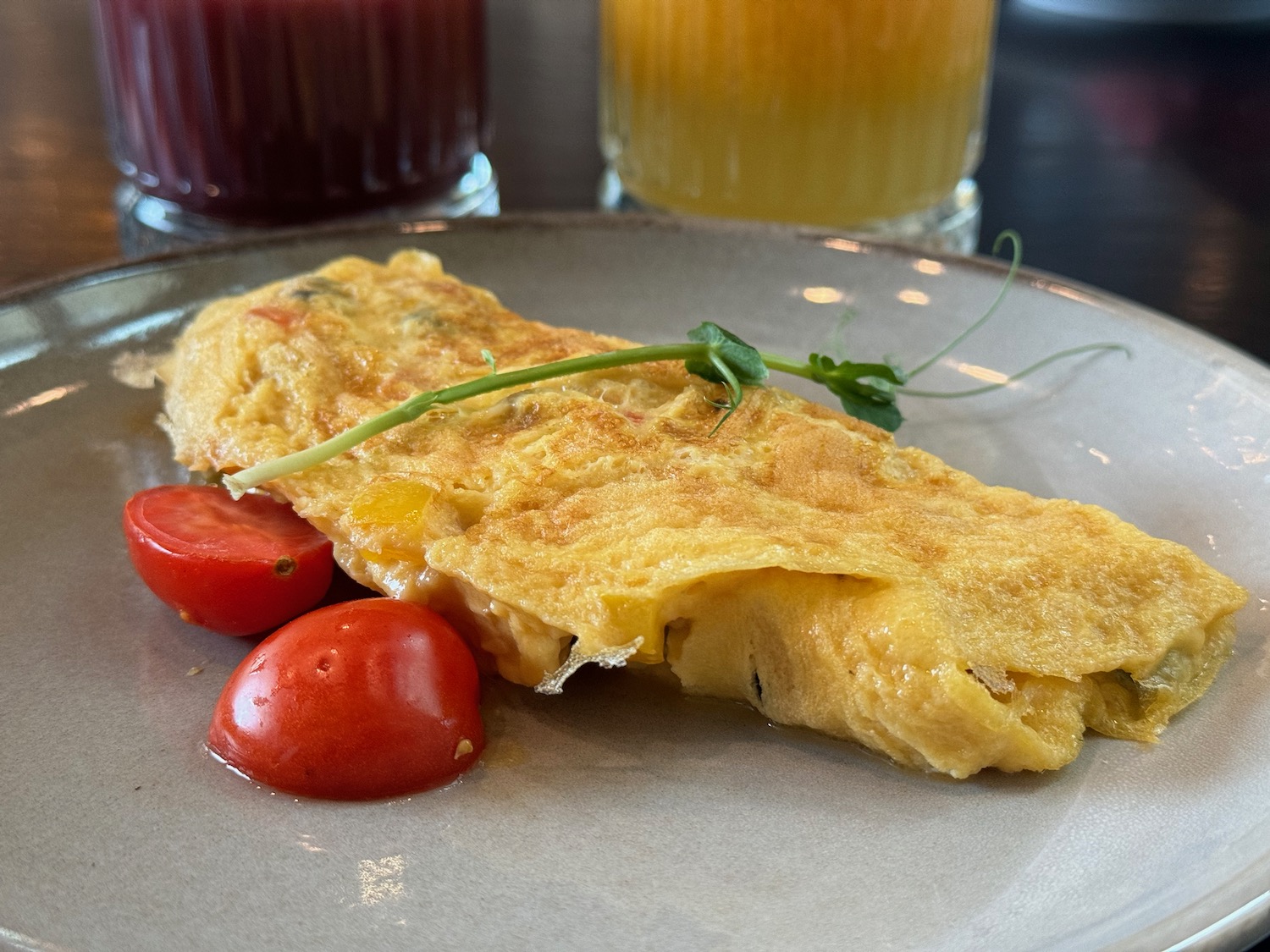 a plate of omelette and cherry tomatoes