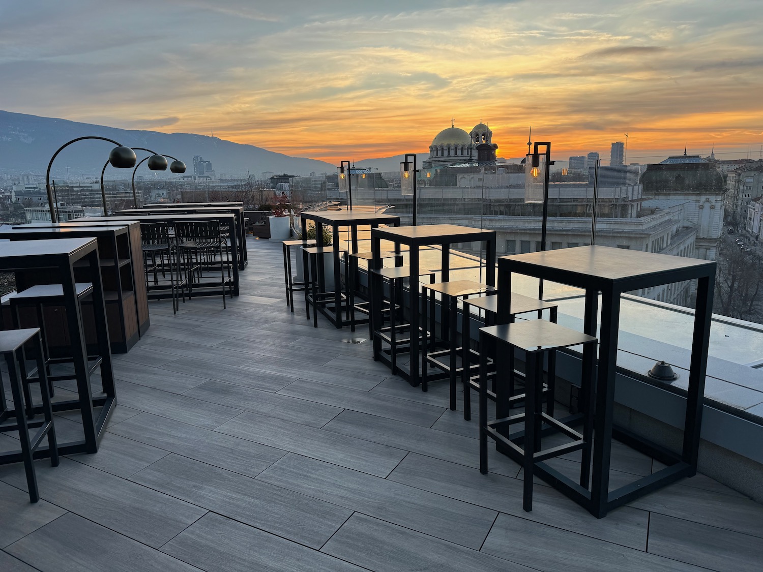 a rooftop with tables and chairs