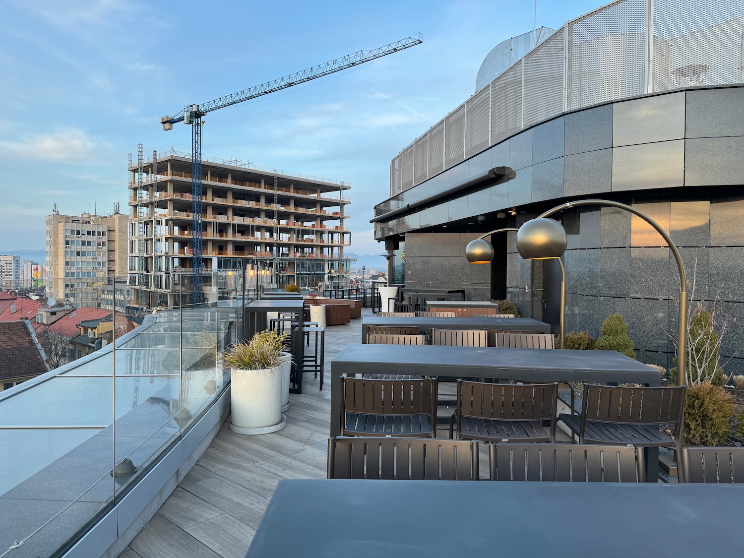 a building with a crane and a building with tables and chairs