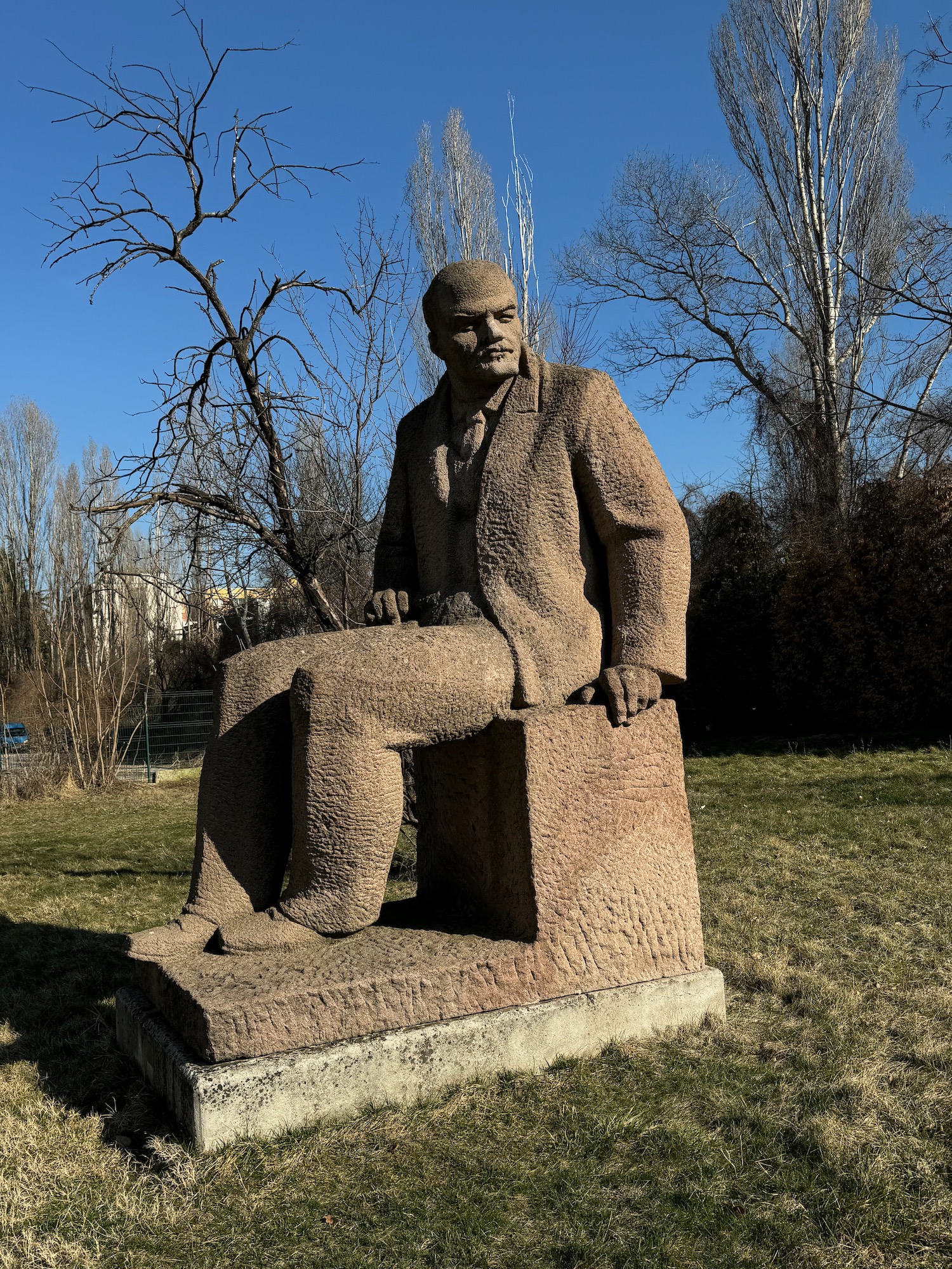a statue of a man sitting on a stone block