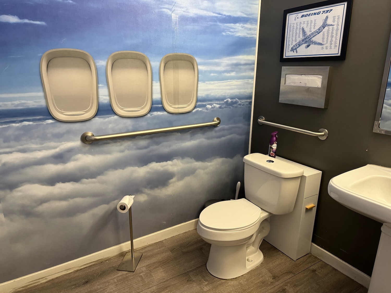 a bathroom with a toilet and airplane mural