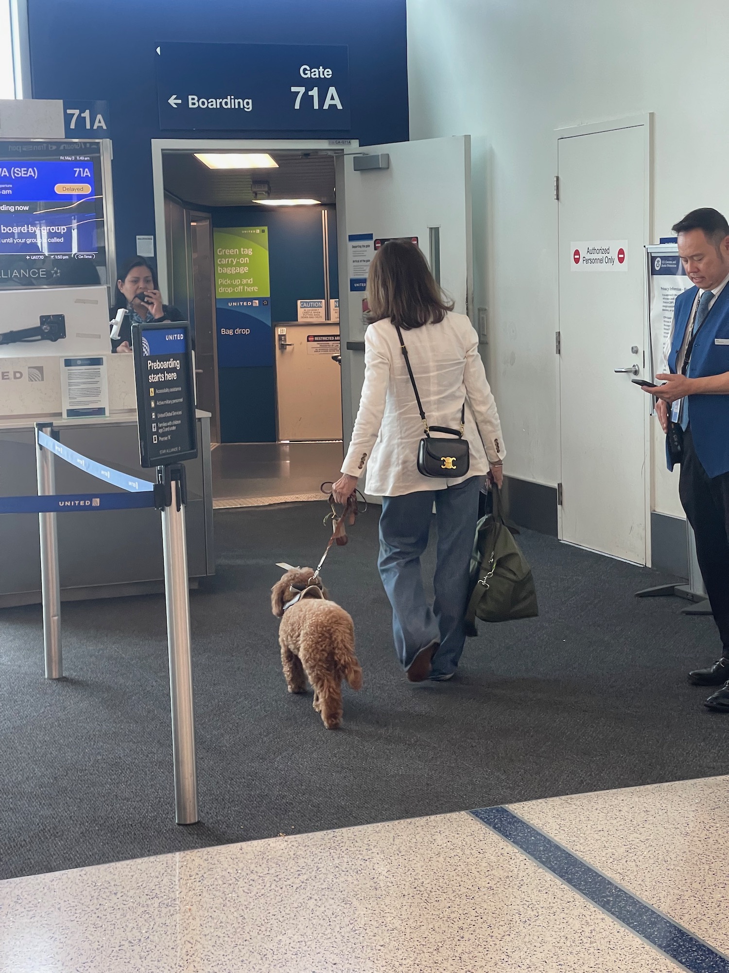 a woman walking a dog in an airport