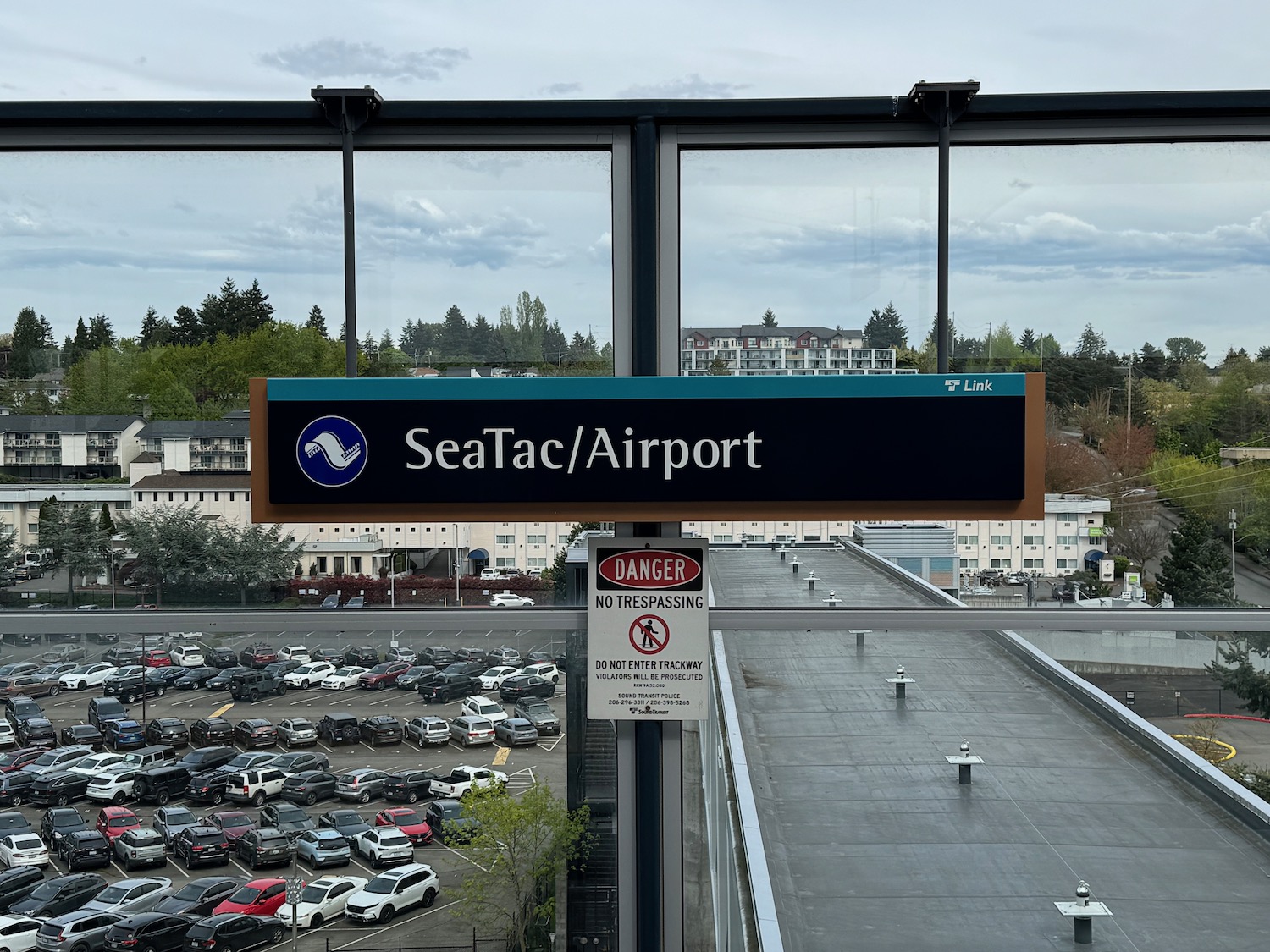 a sign on a pole with a parking lot in the background