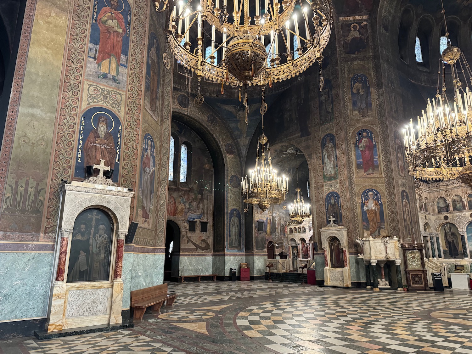 a large ornate room with paintings and a chandelier