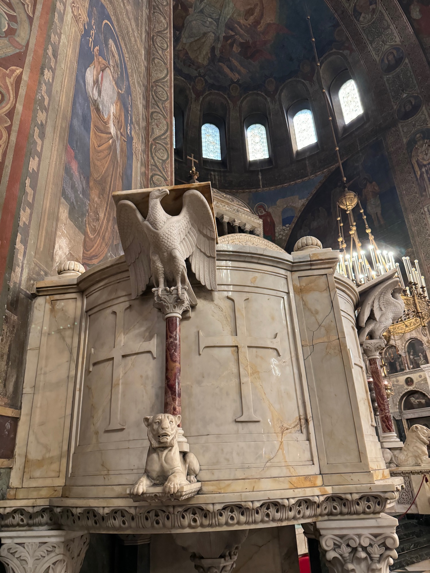 a white stone altar with a lion and a bird statue