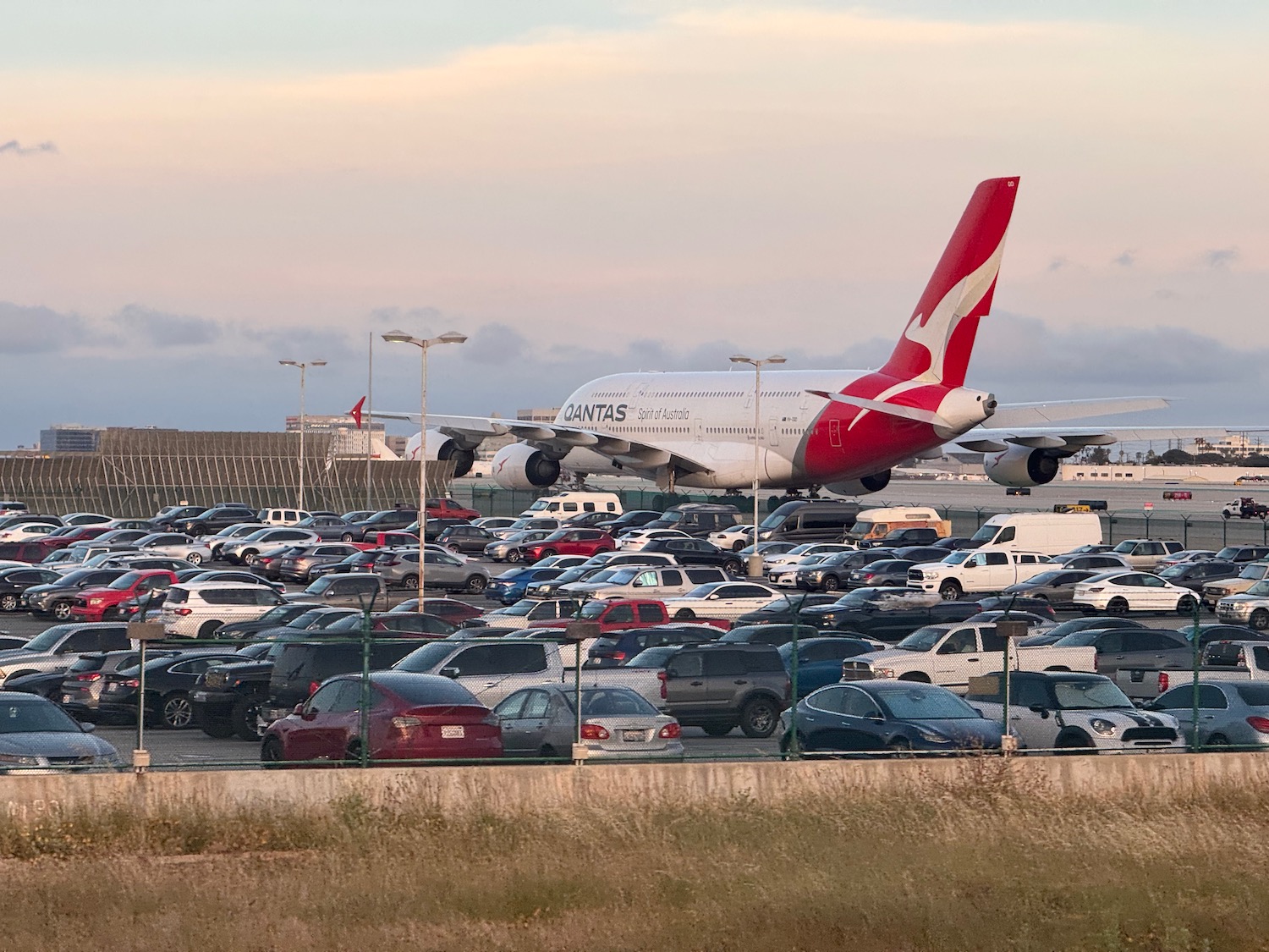 a large airplane in a parking lot with cars
