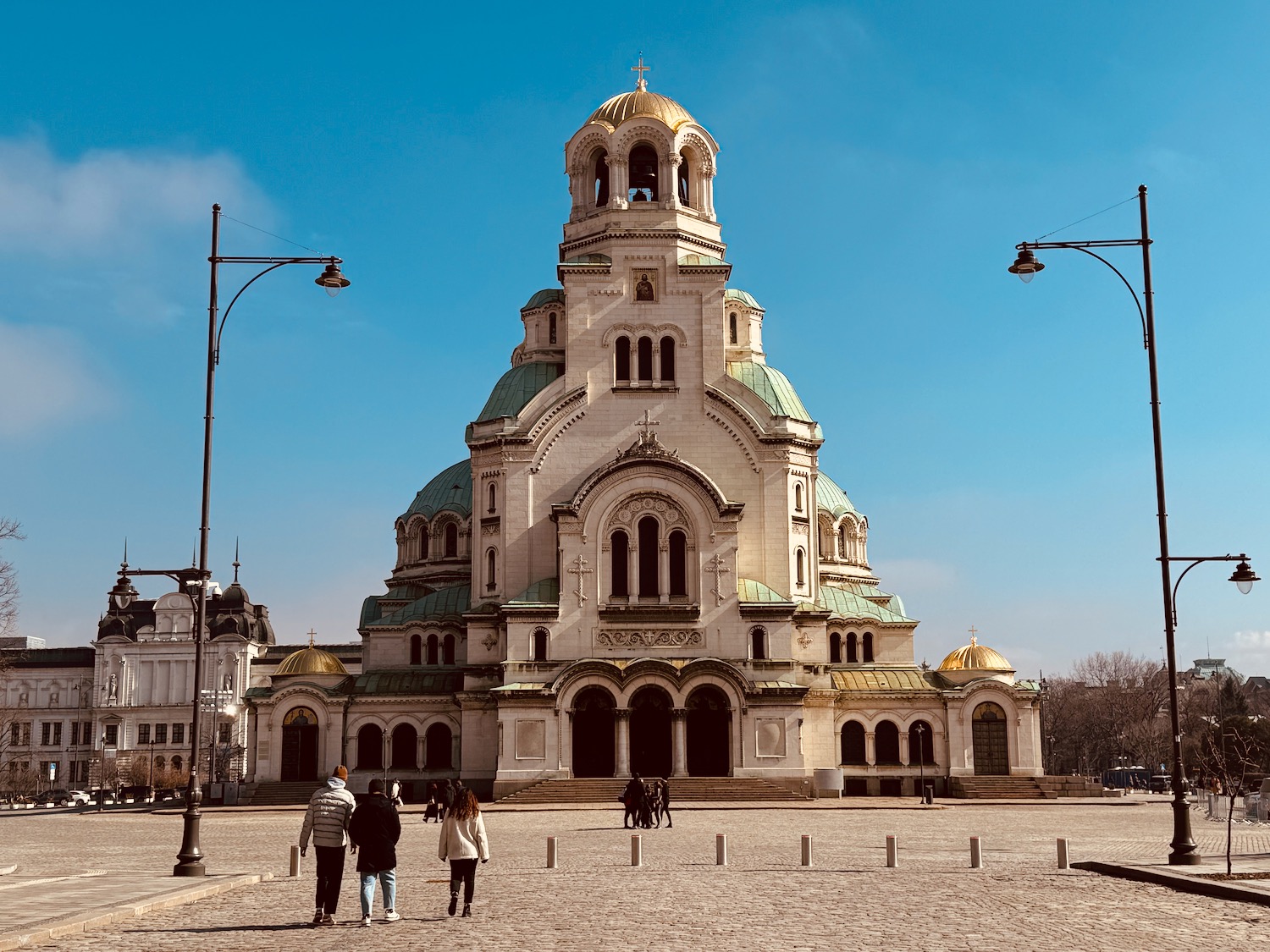 a large building with a bell tower and people walking around