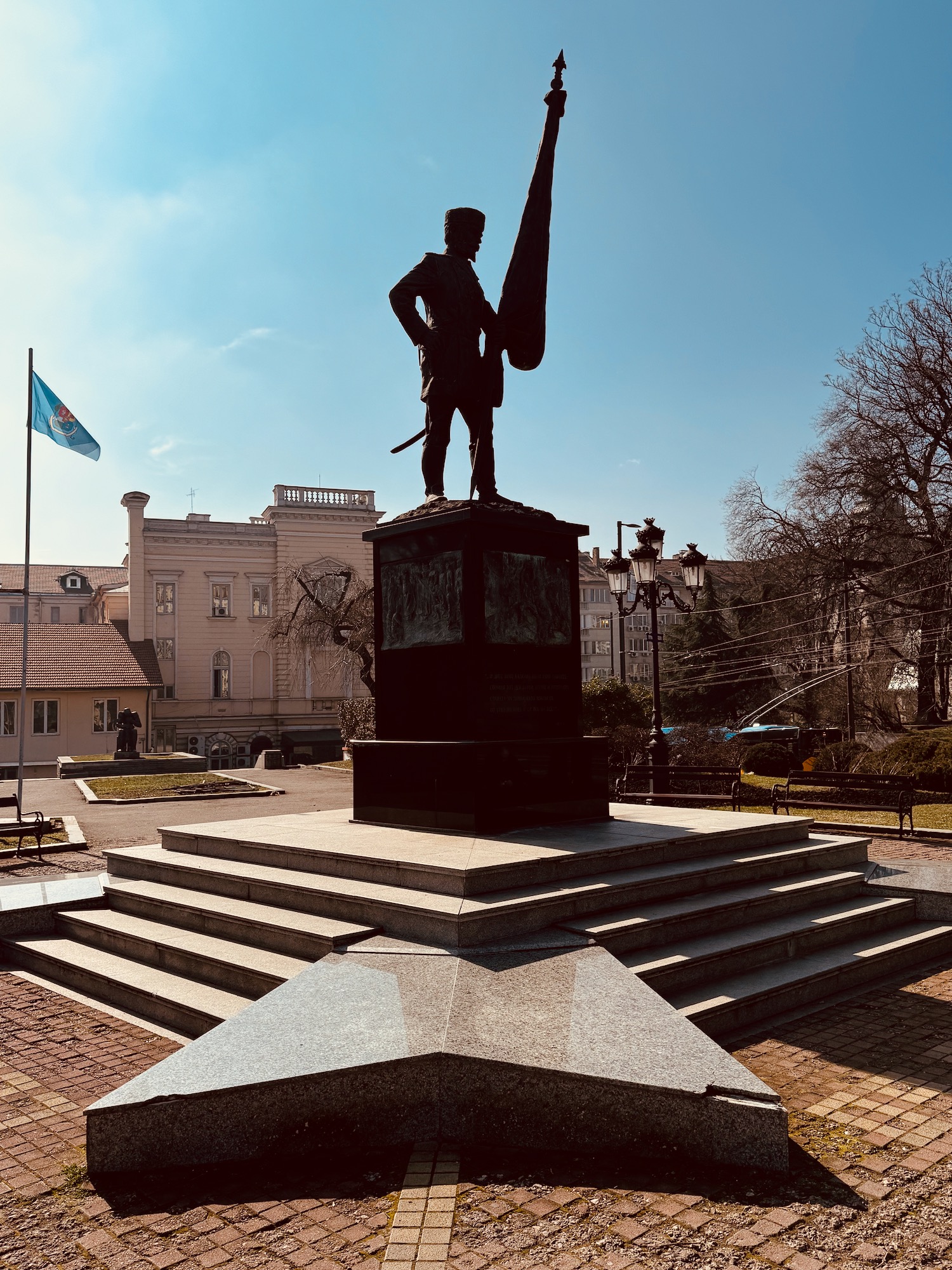 a statue of a man holding a sword and a flag