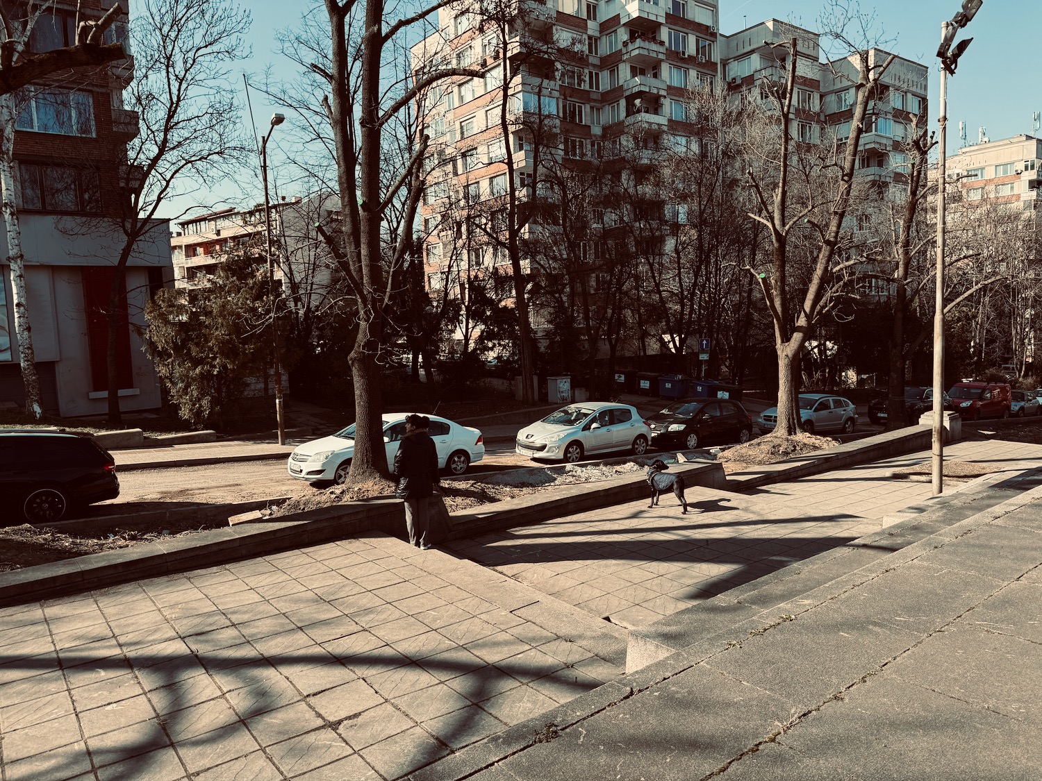 a person standing on a sidewalk next to a building