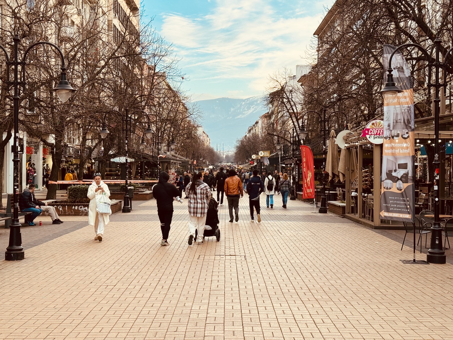 a group of people walking on a brick sidewalk