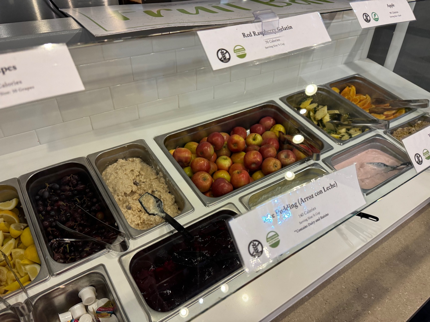 a trays of fruit and vegetables in a display case