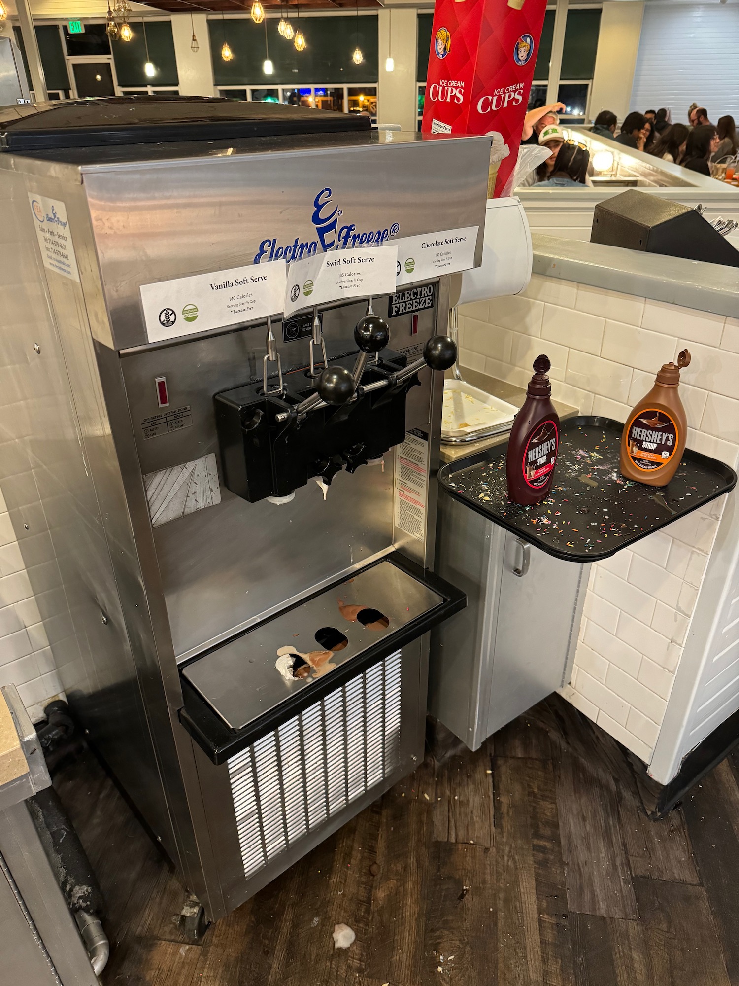 a machine with a shelf and bottles on the side