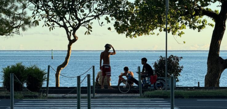 a group of people sitting on a bench near a body of water