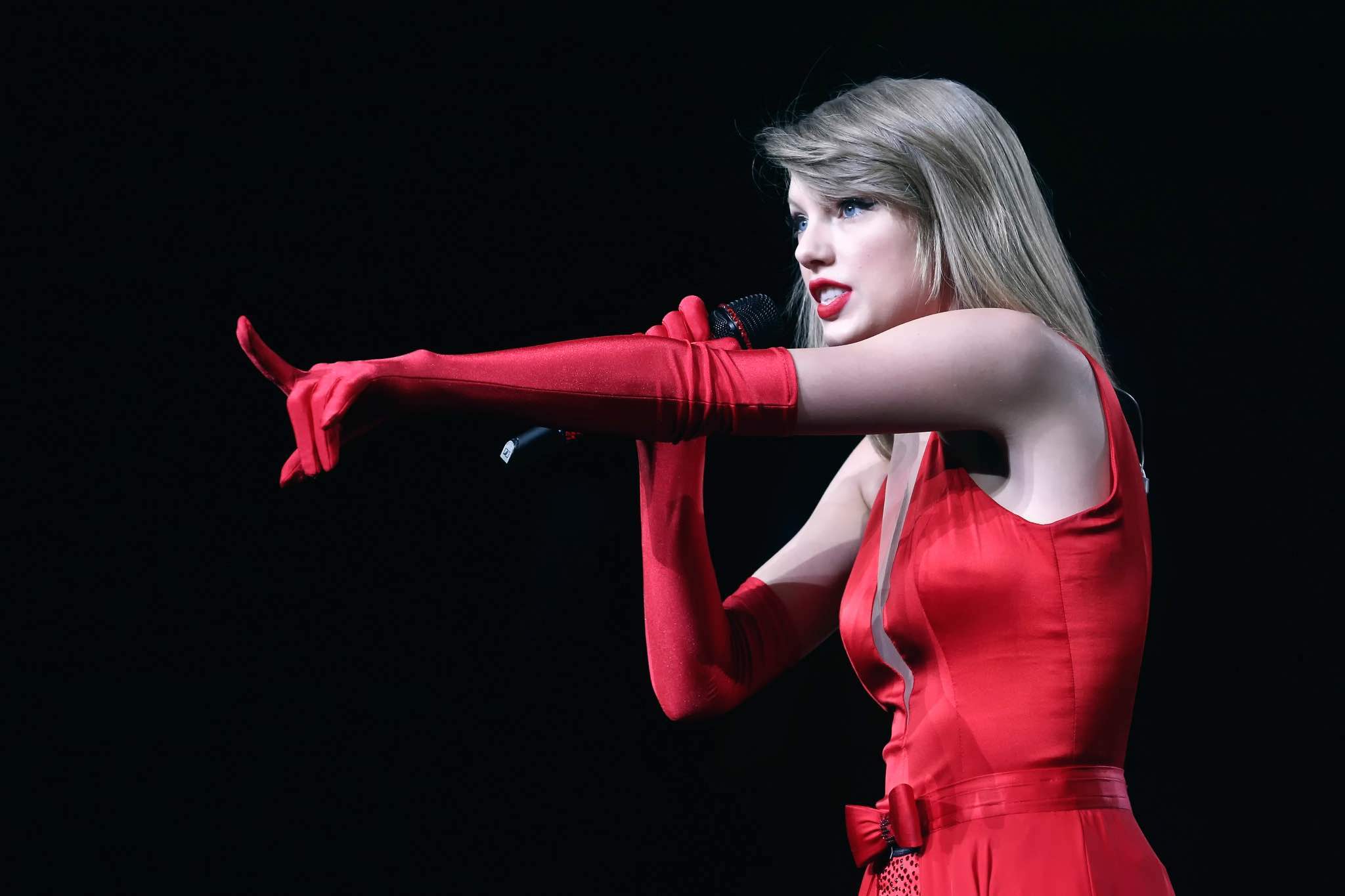 a woman in a red dress holding a microphone