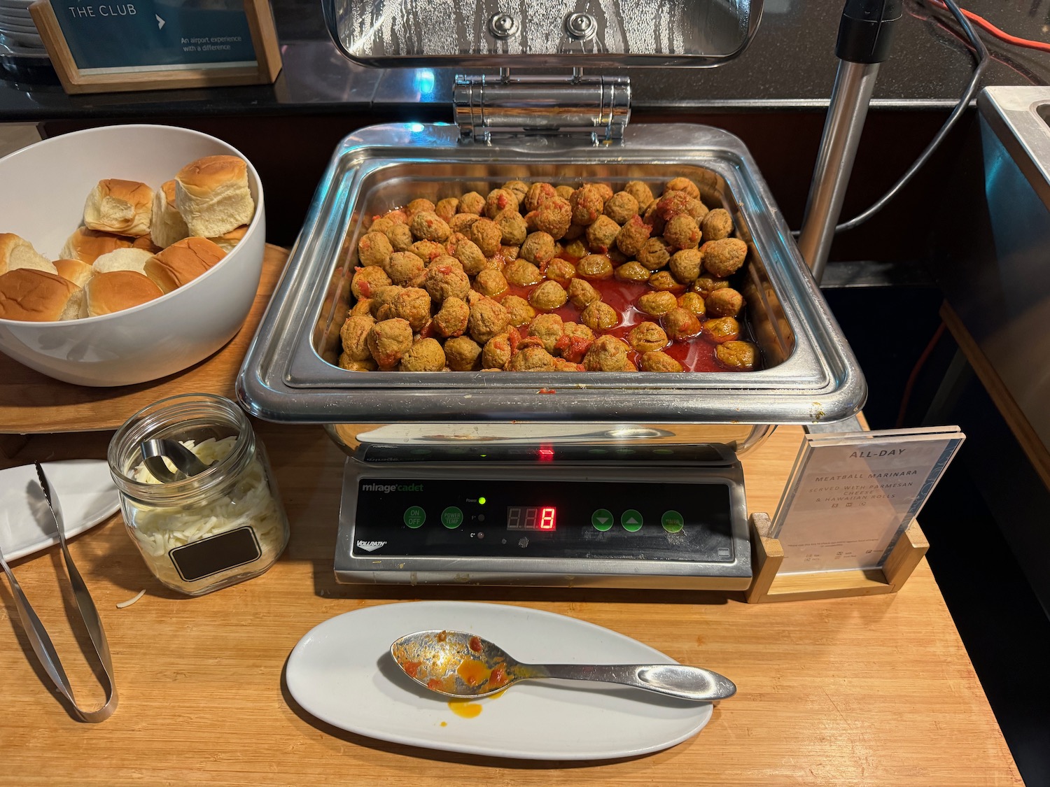 food on a counter with a plate of bread and a spoon