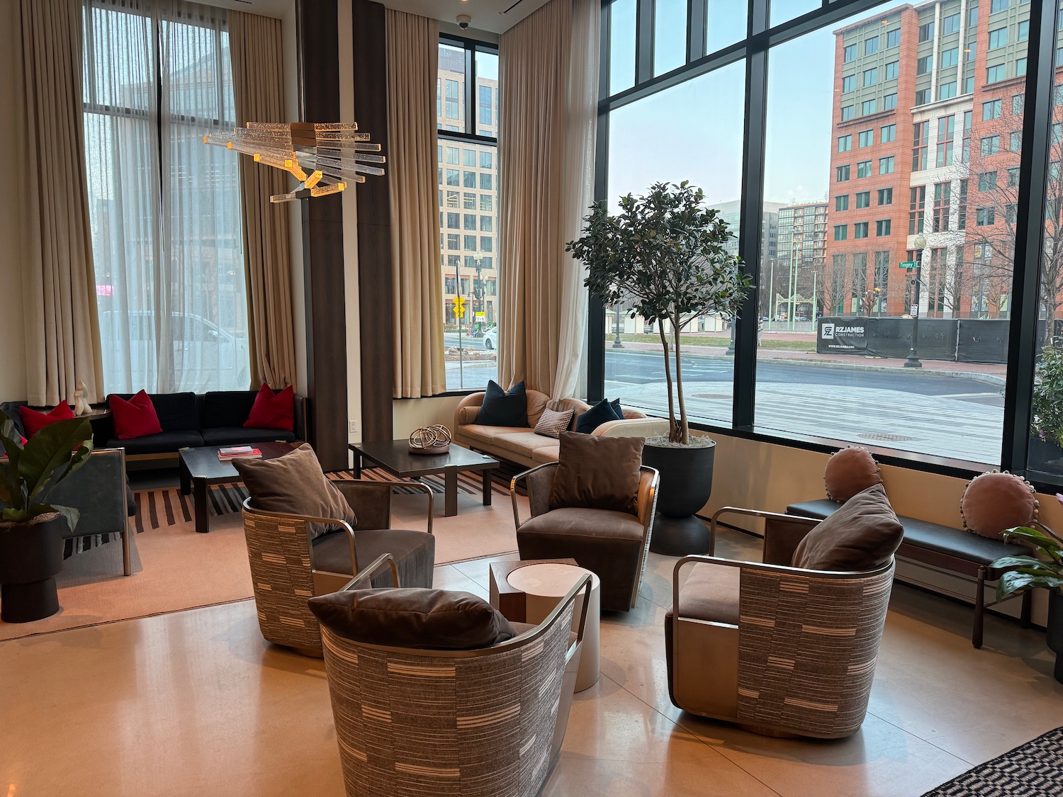 a room with a large window and chairs and a tree