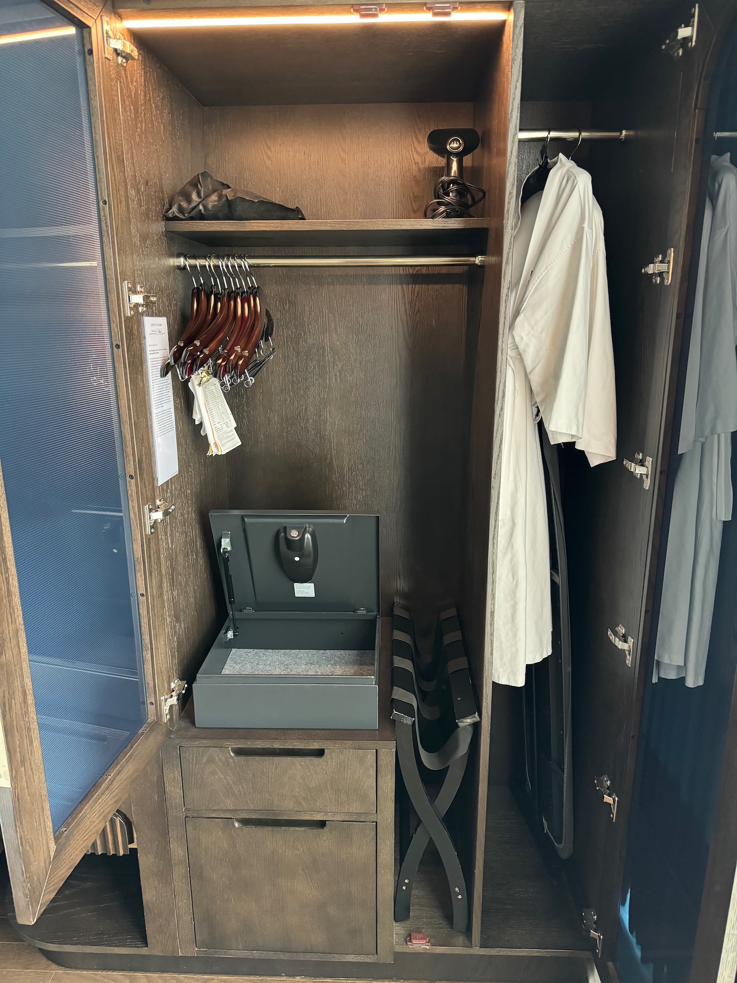 a closet with a small open box and a coat swinger
