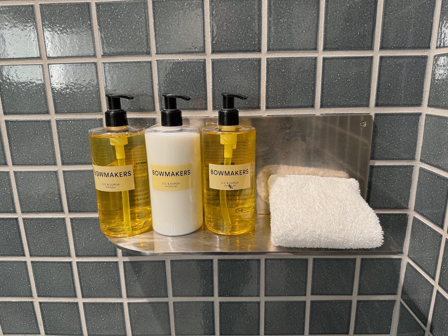 a group of soap bottles and a towel on a shelf