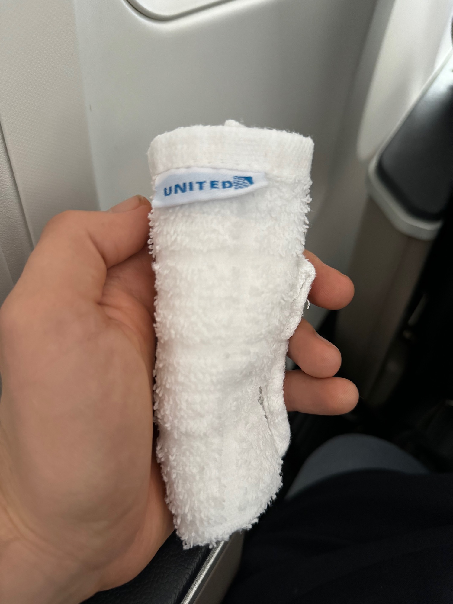 a hand holding a small white towel