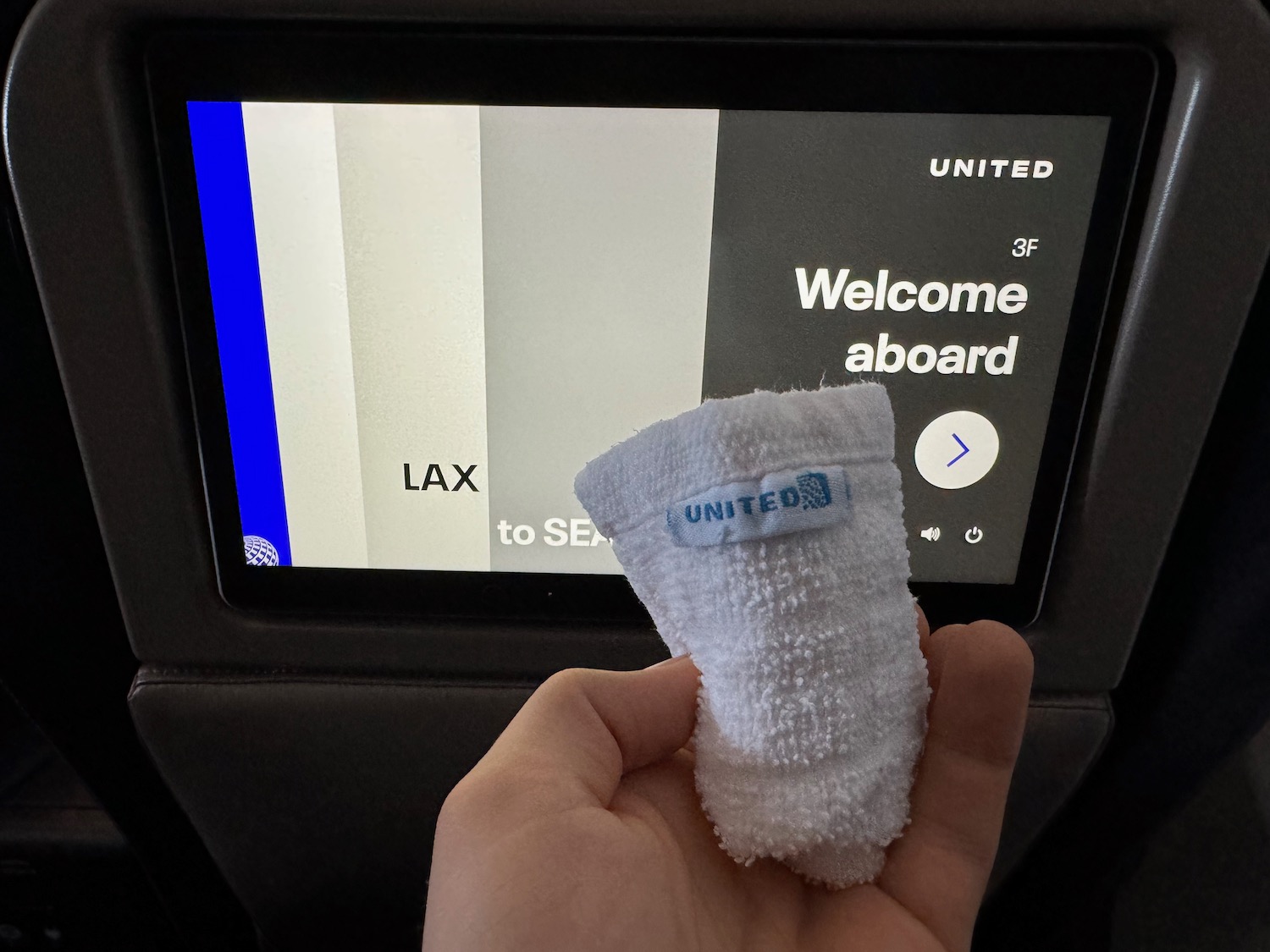 a hand holding a towel in front of a screen