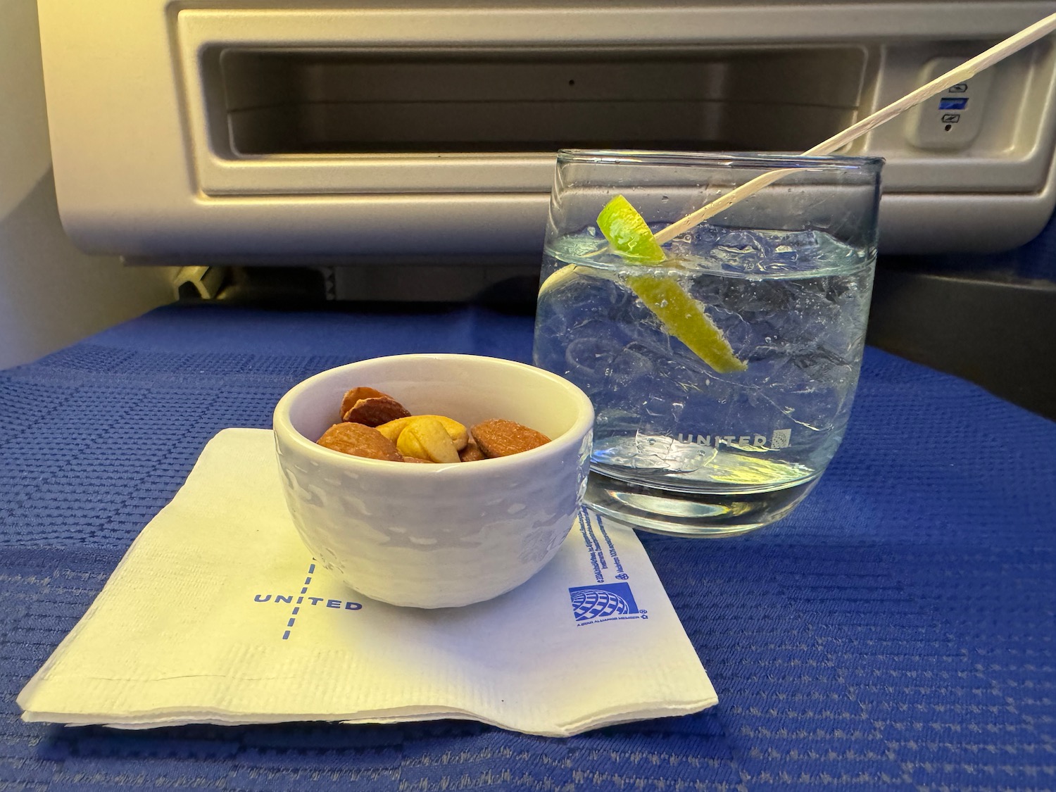 a bowl of nuts and a glass of water on a table