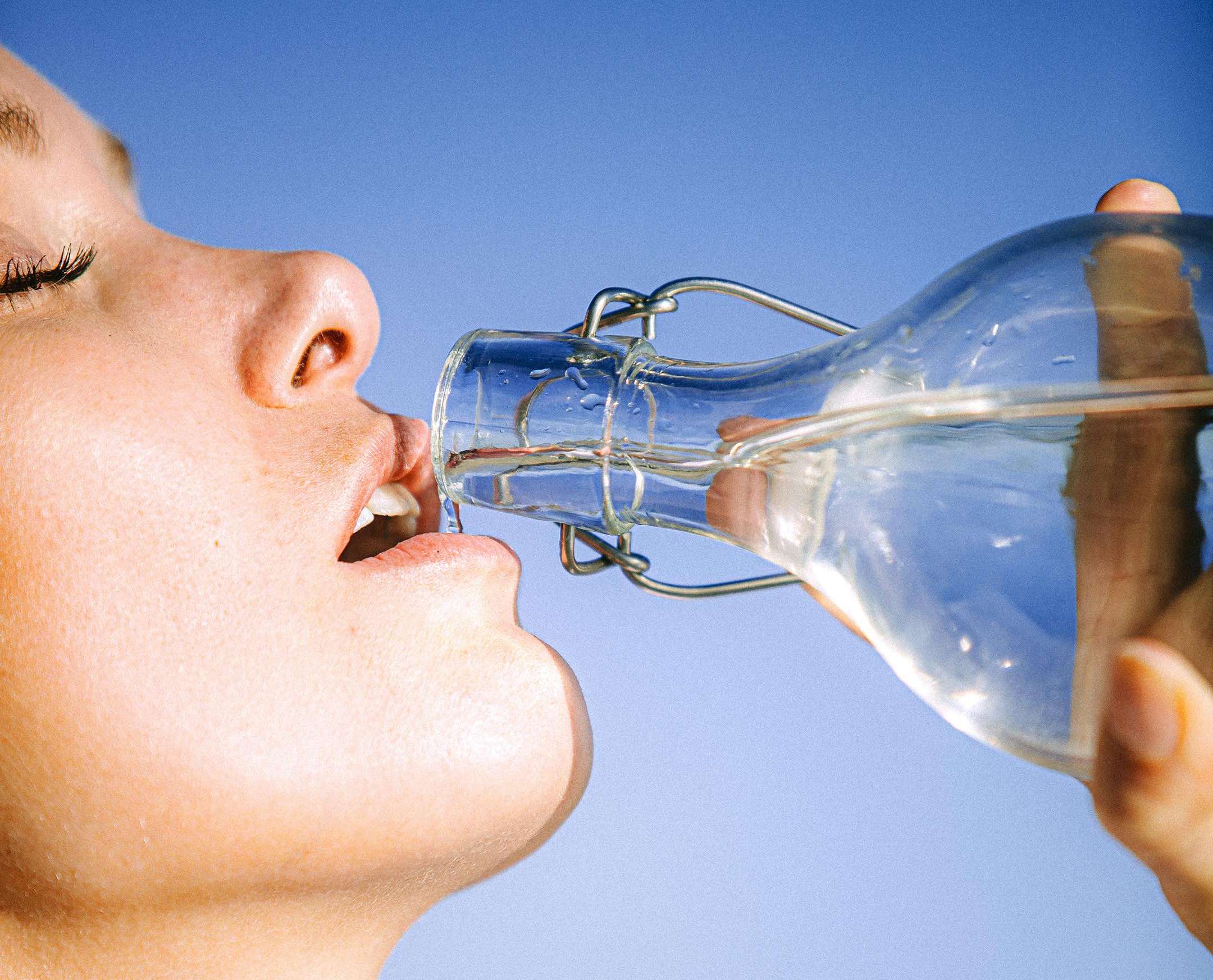 a person drinking water from a bottle