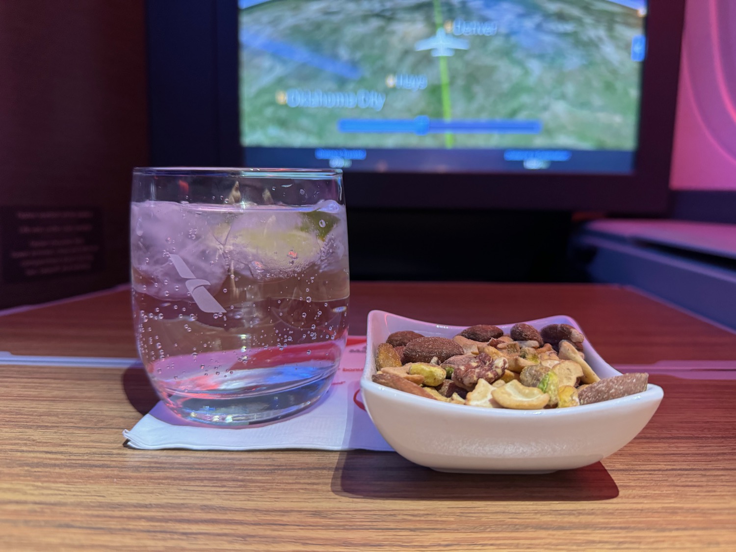 a bowl of nuts and a glass of water on a table