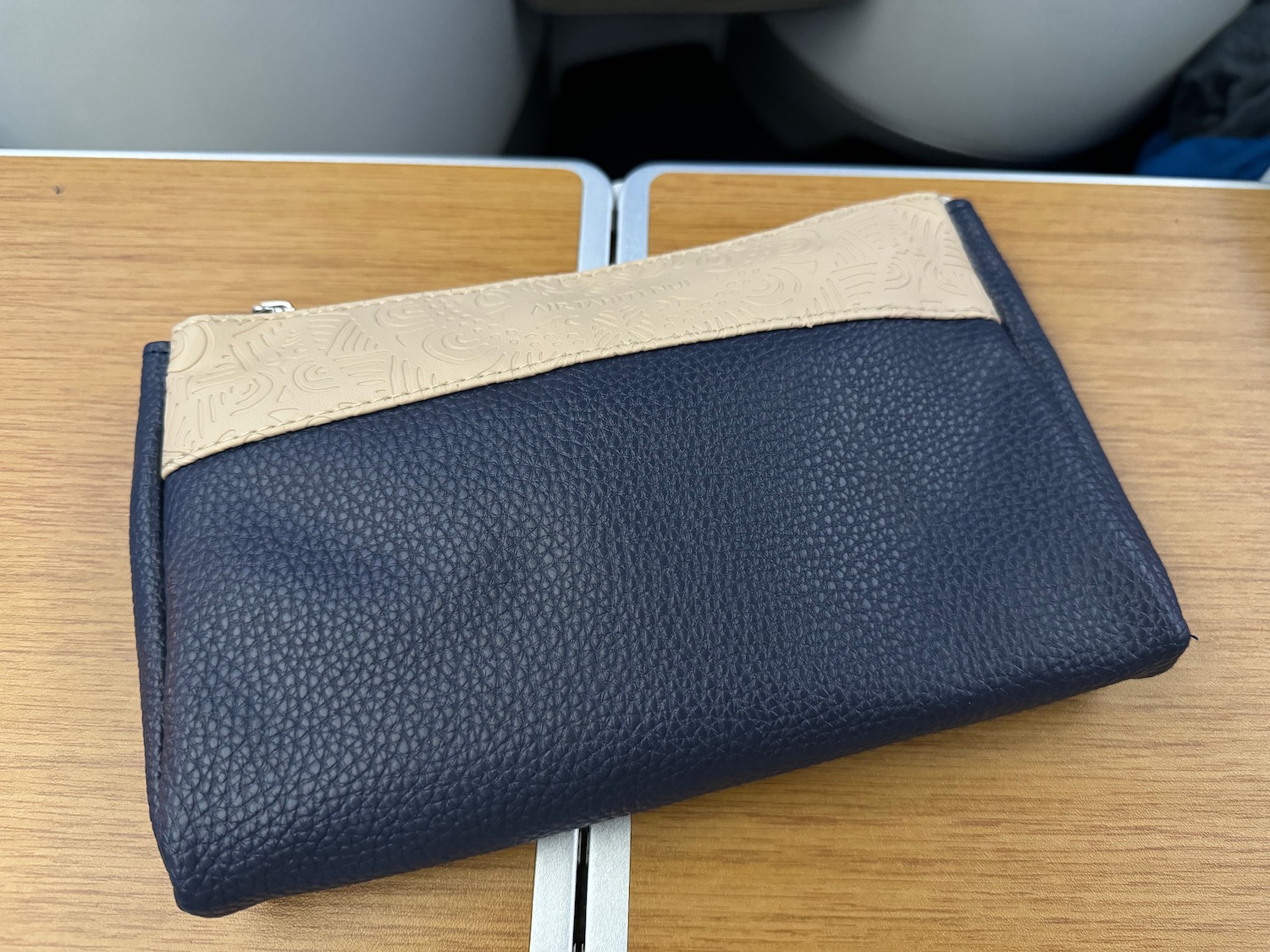 a blue and tan purse on a table