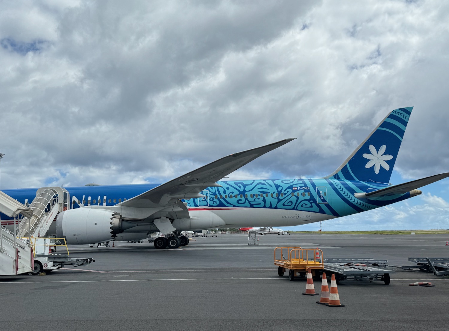 a blue and white airplane on a runway