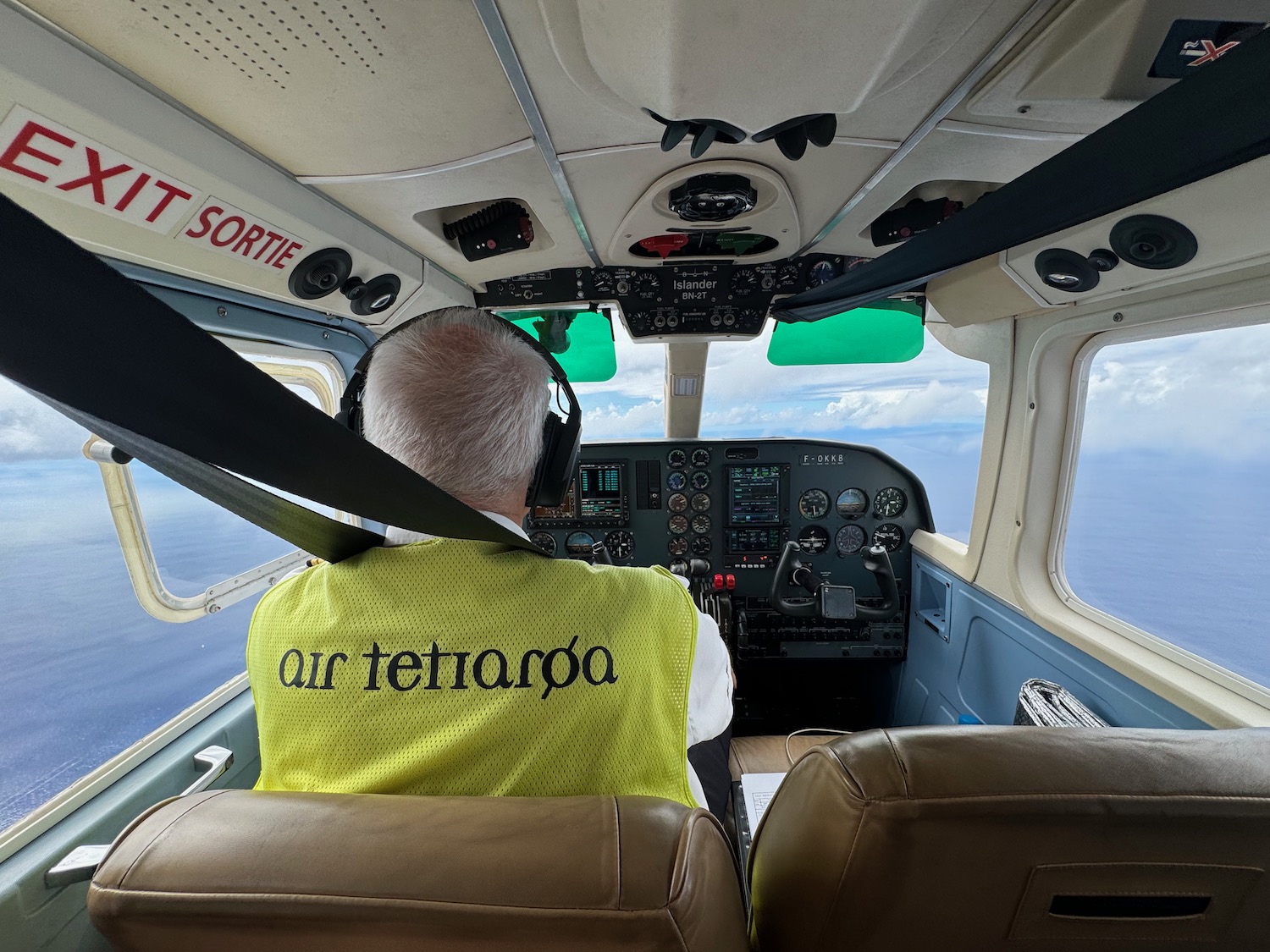 a man in a yellow vest in a plane