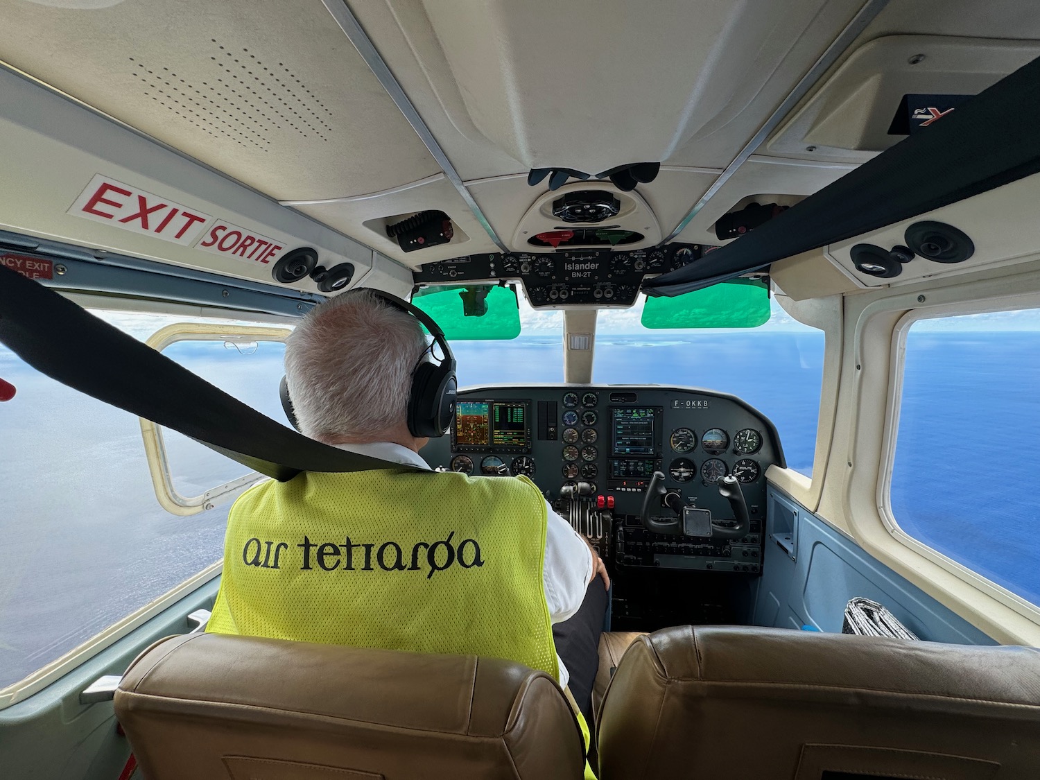 a man in a yellow vest in a plane