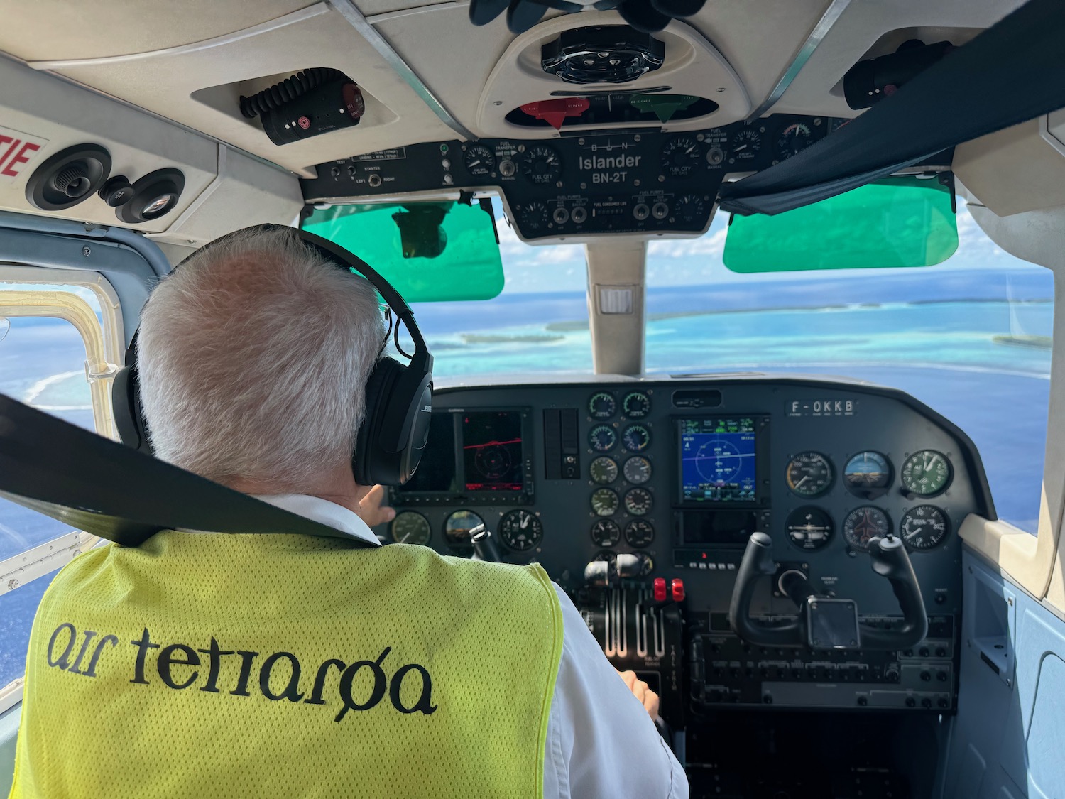 a man in a yellow vest in a cockpit of a plane