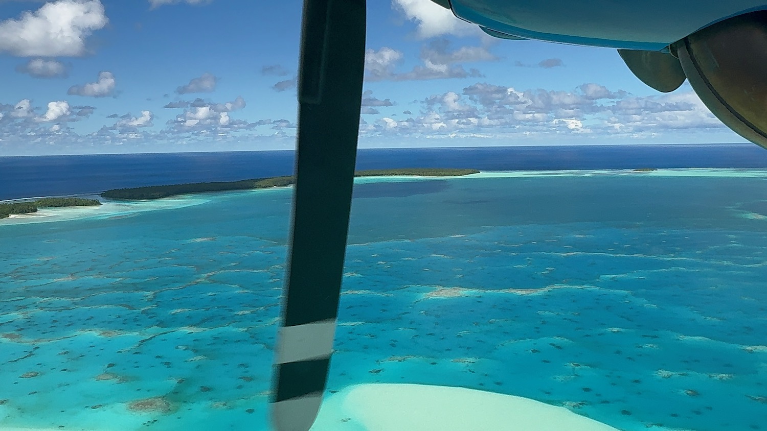 an airplane window with an island in the background