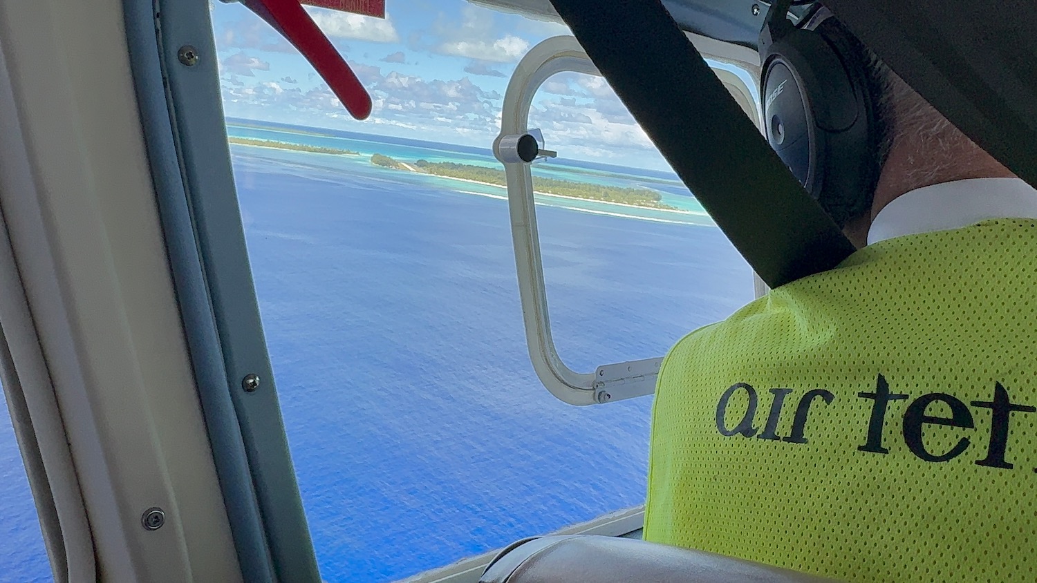 a yellow vest on a seat by a window with a body of water