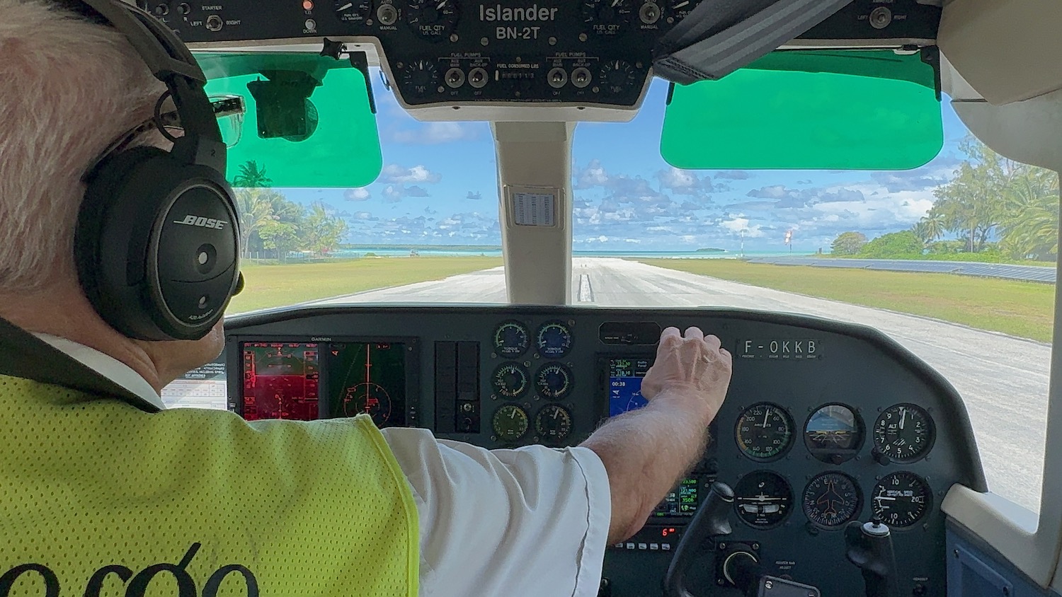 a man in a yellow vest on a plane