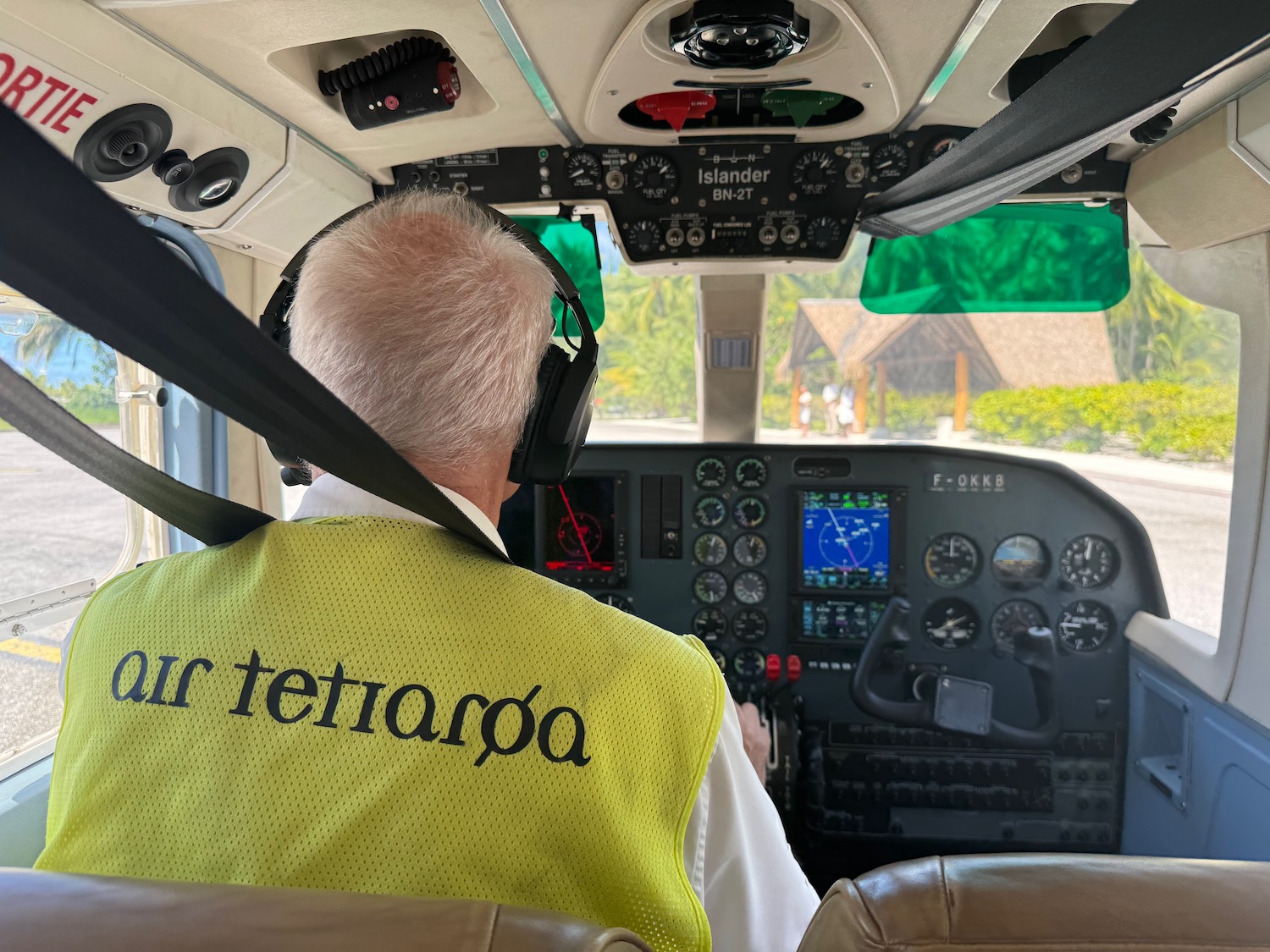 a man in a yellow vest in a cockpit of a plane