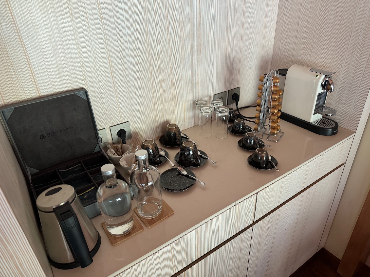 a counter with a coffee maker and glasses