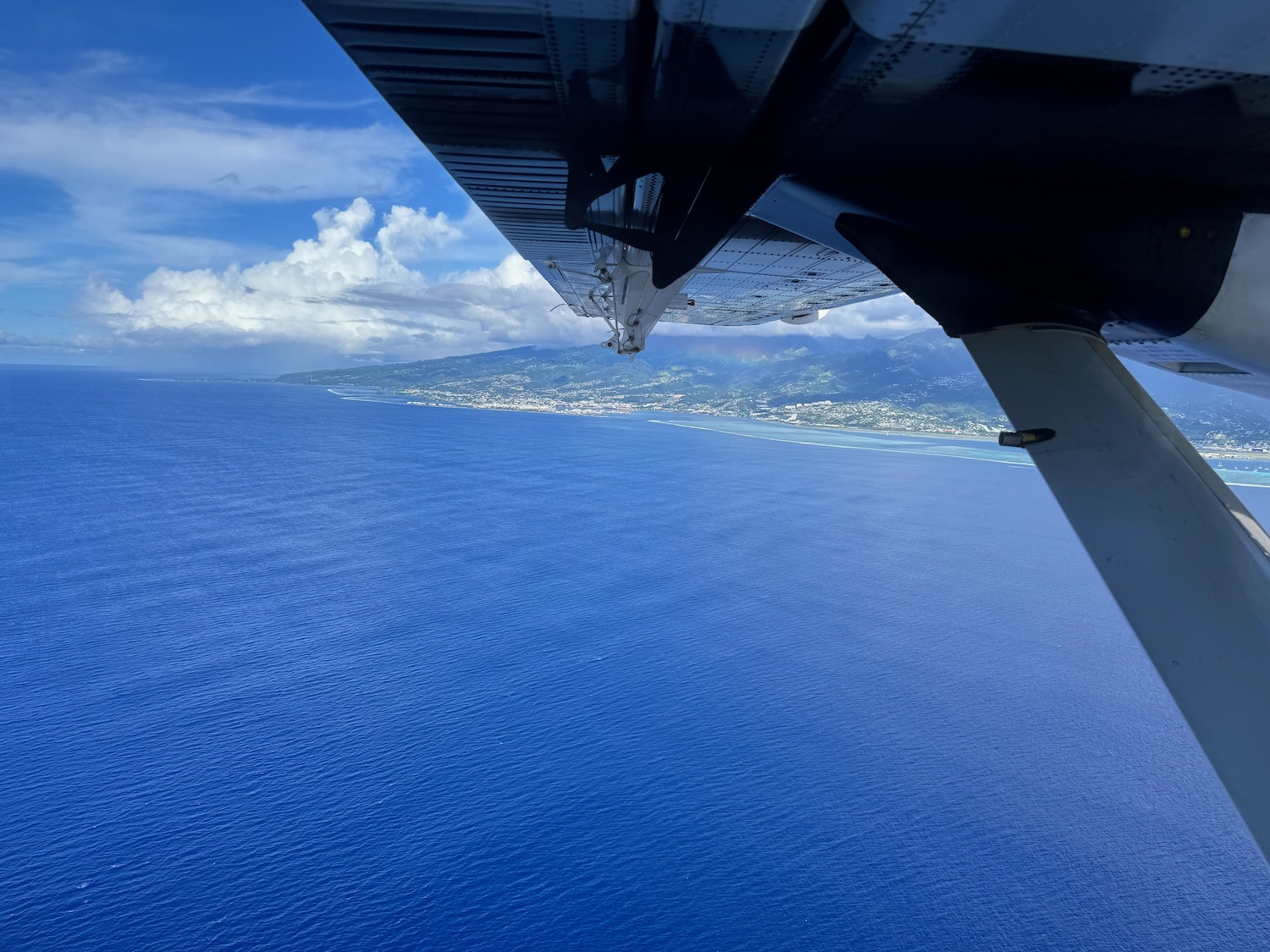 an airplane wing over the ocean