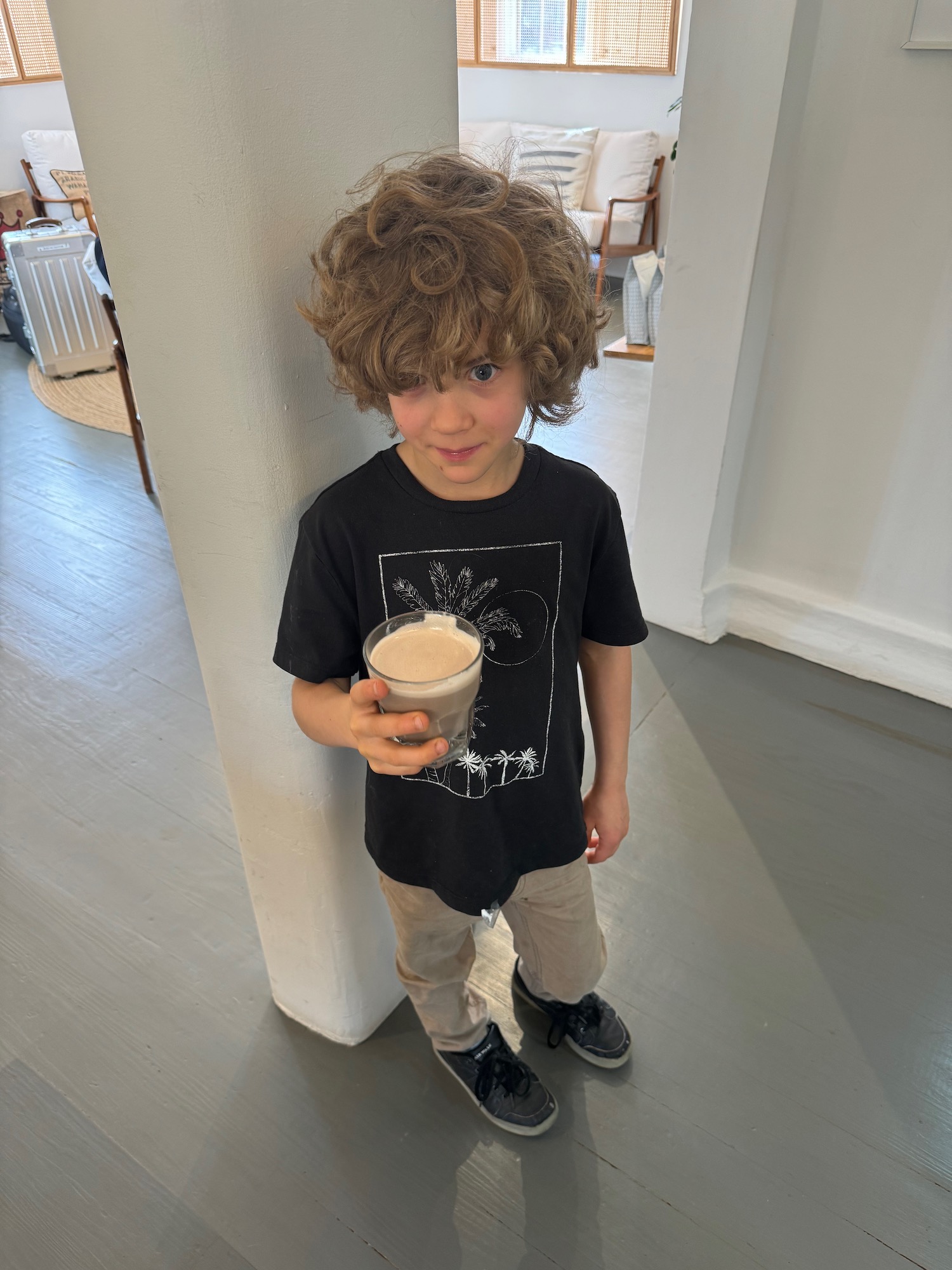 a boy holding a glass of milk