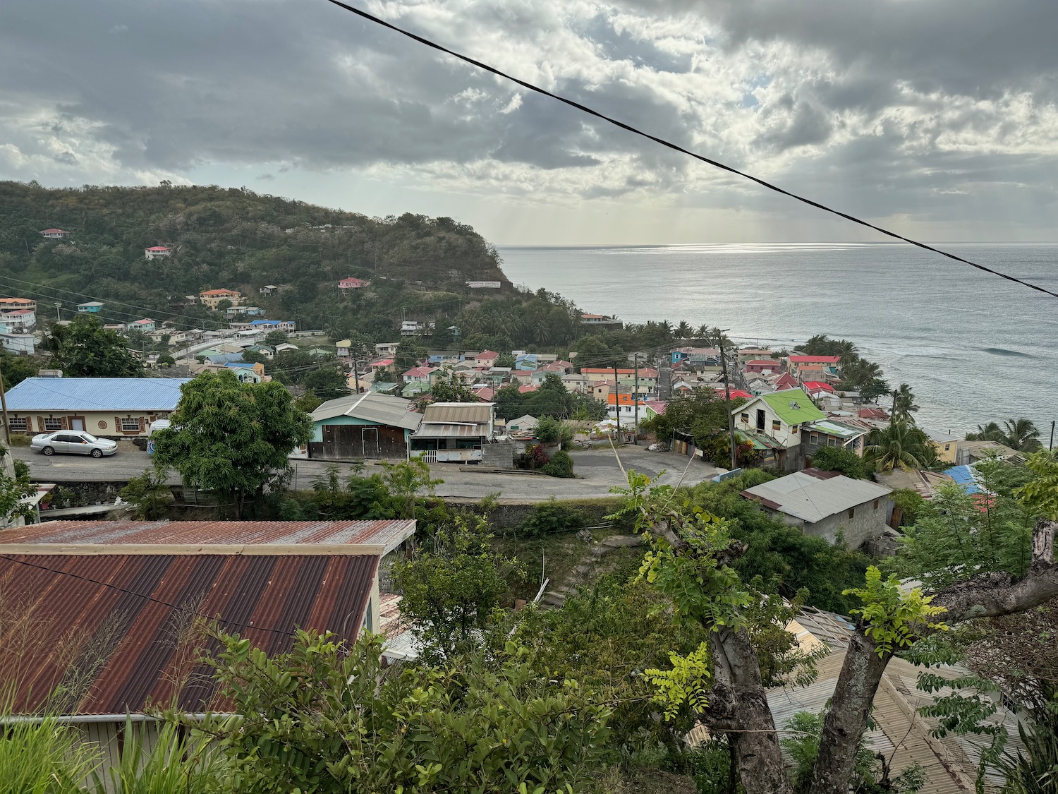 a view of a town and the ocean from a high above power line