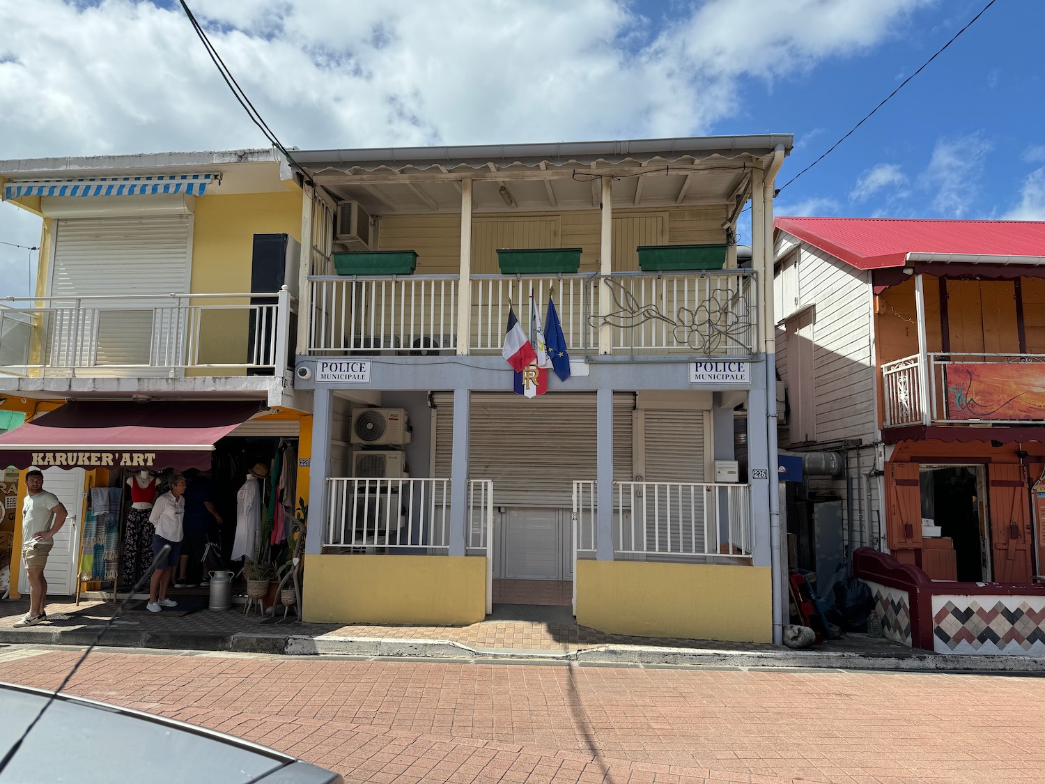 a building with a balcony and people walking in the street