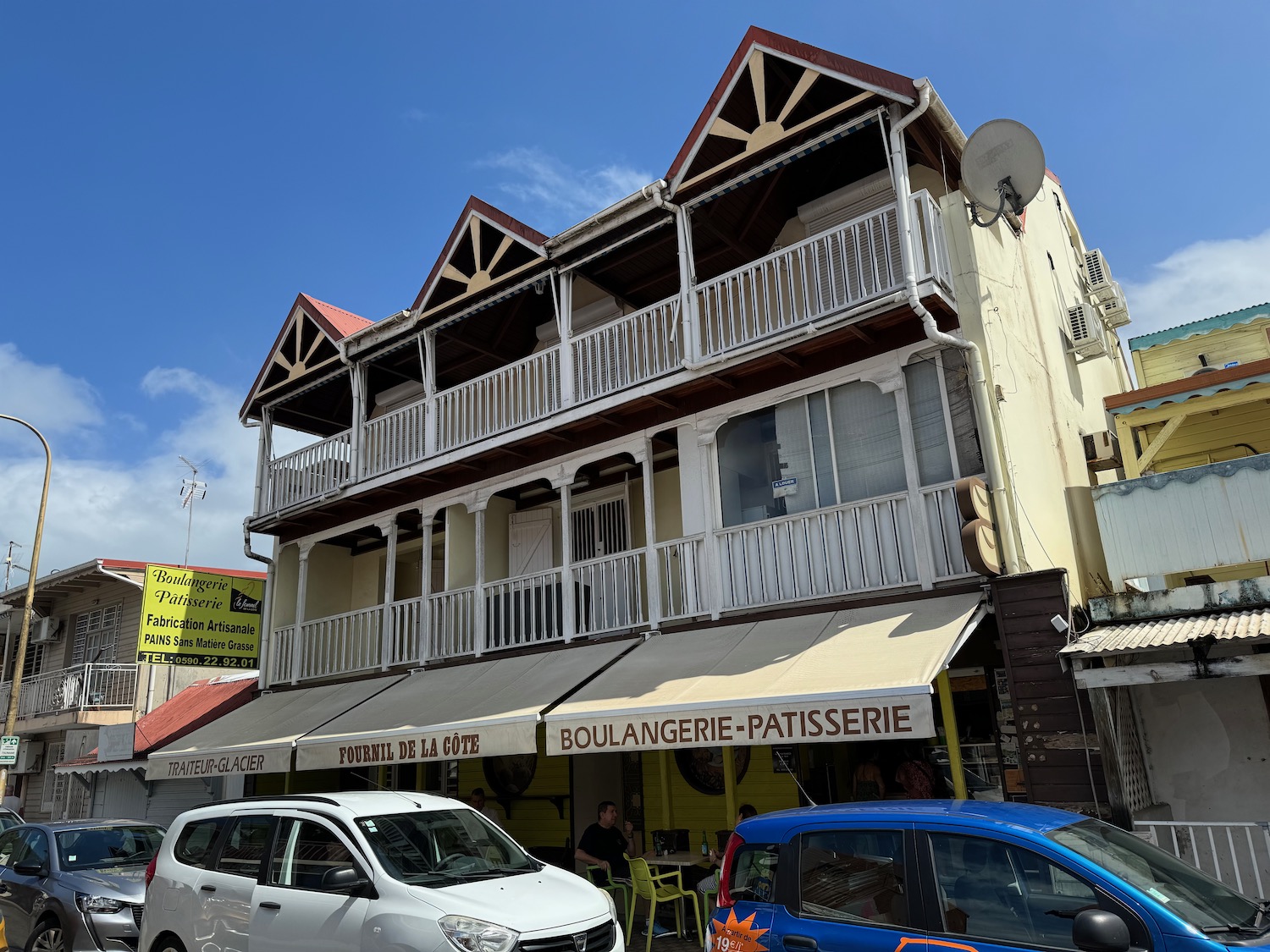 a building with a balcony and a car parked on the side