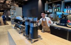 a man standing behind a counter with coffee beans