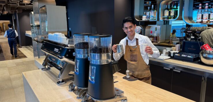 a man standing behind a counter with coffee beans