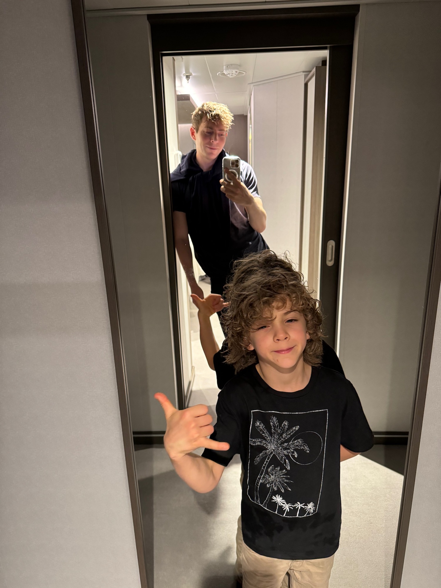a boy taking a selfie in a mirror